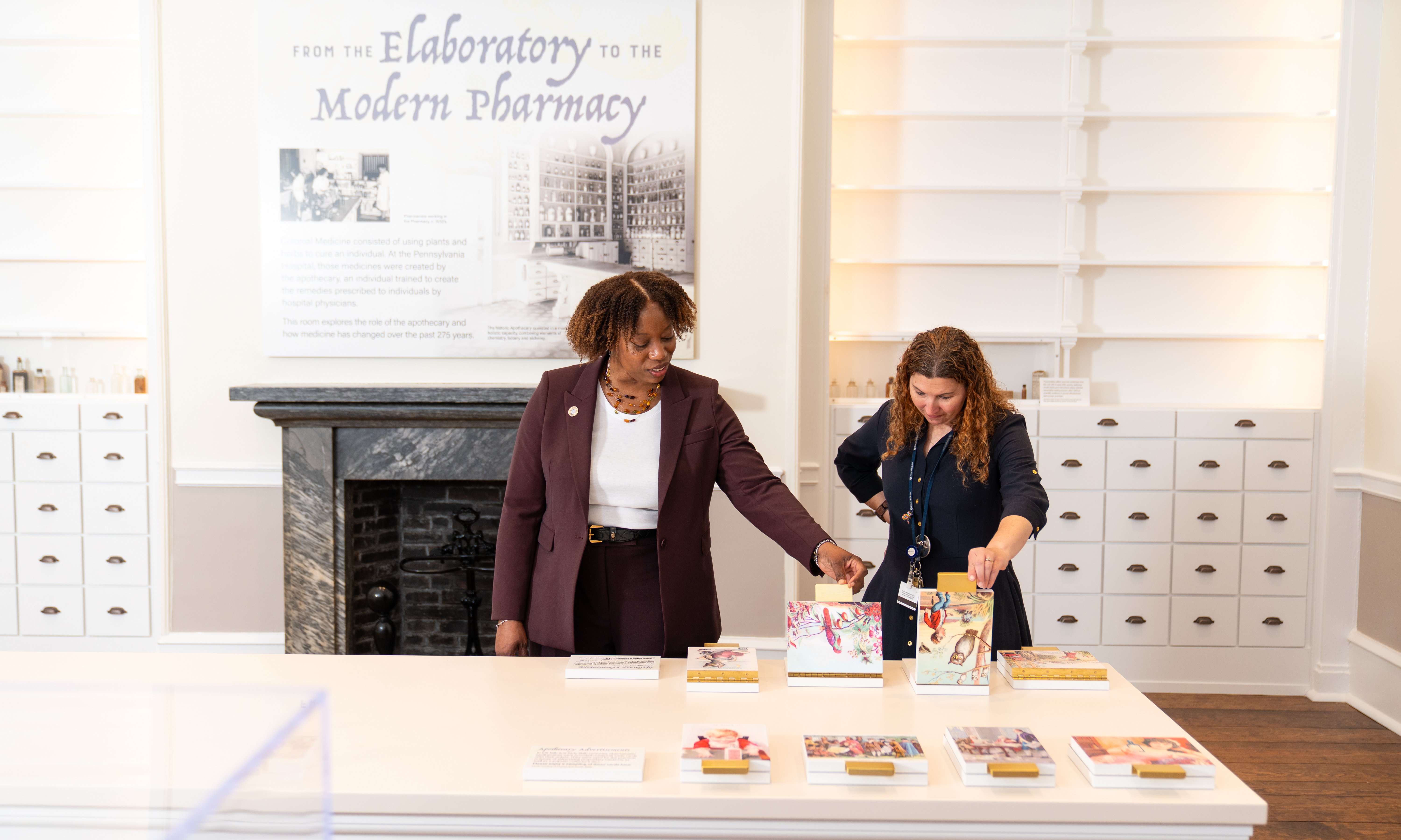 Alicia Gresham and Stacey Peeples interacting with items in the apothecary of the Pennsylvania Hospital museum
