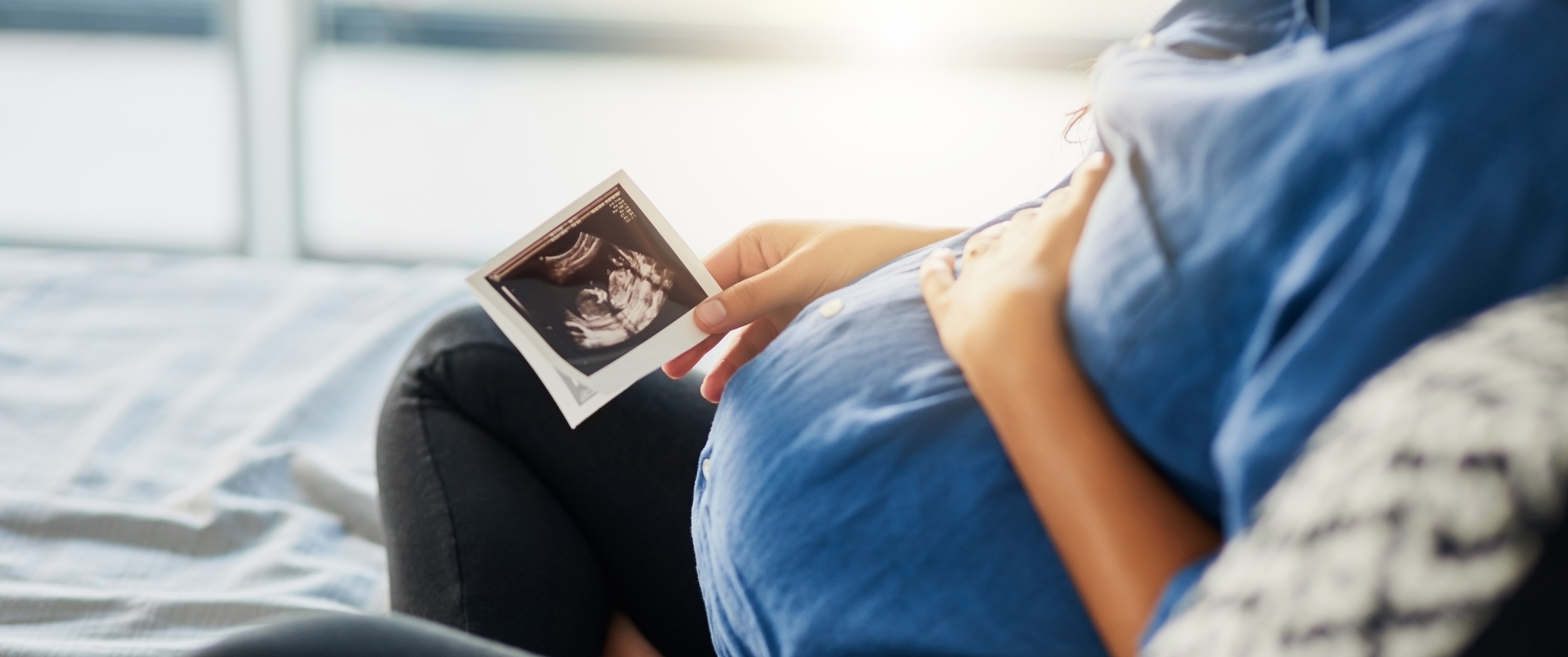  Closeup shot of an unrecognizable pregnant woman holding an ultrasound scan