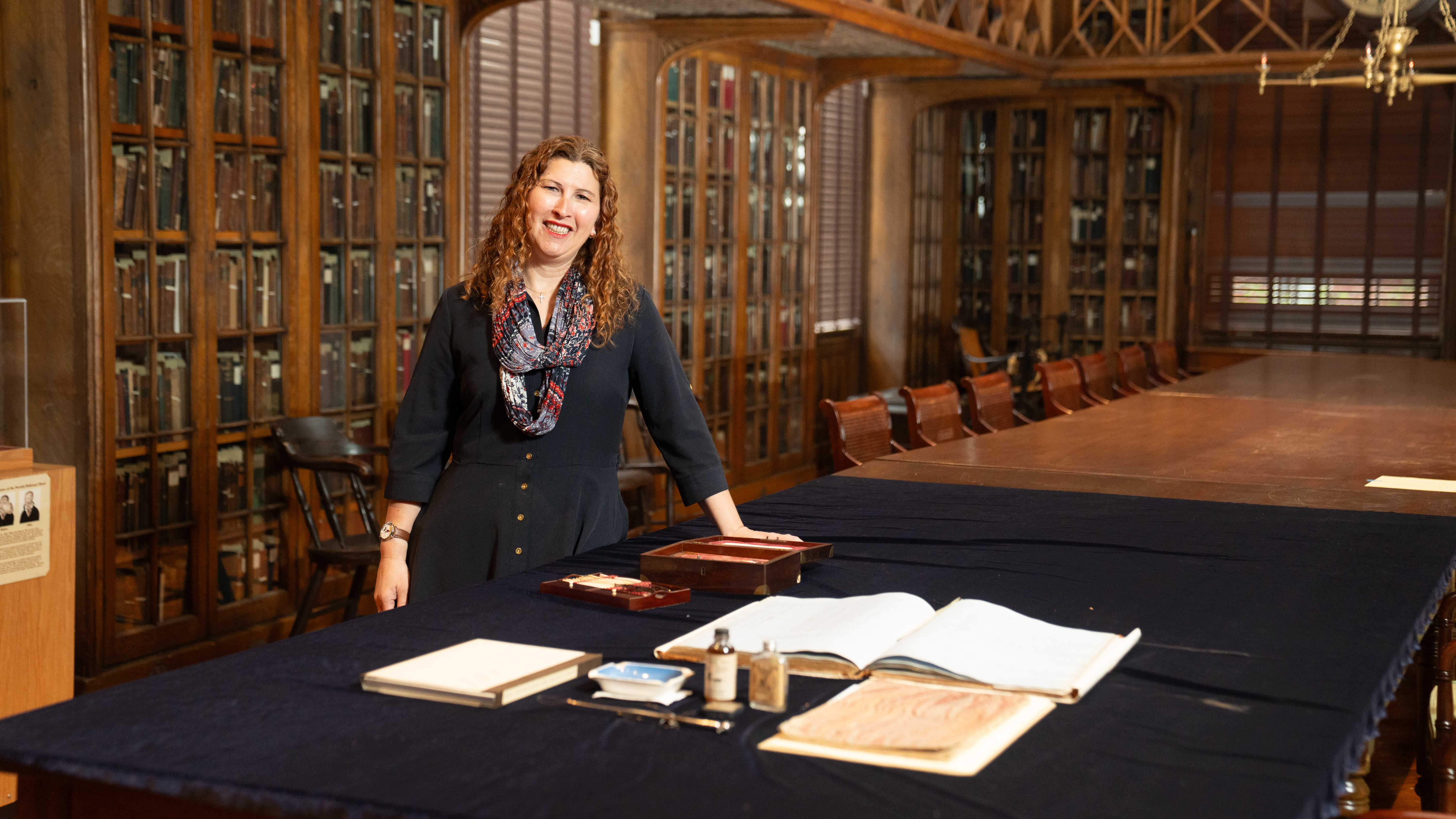 Stacey Peeples in the historic library with an assortment of artifacts on a table