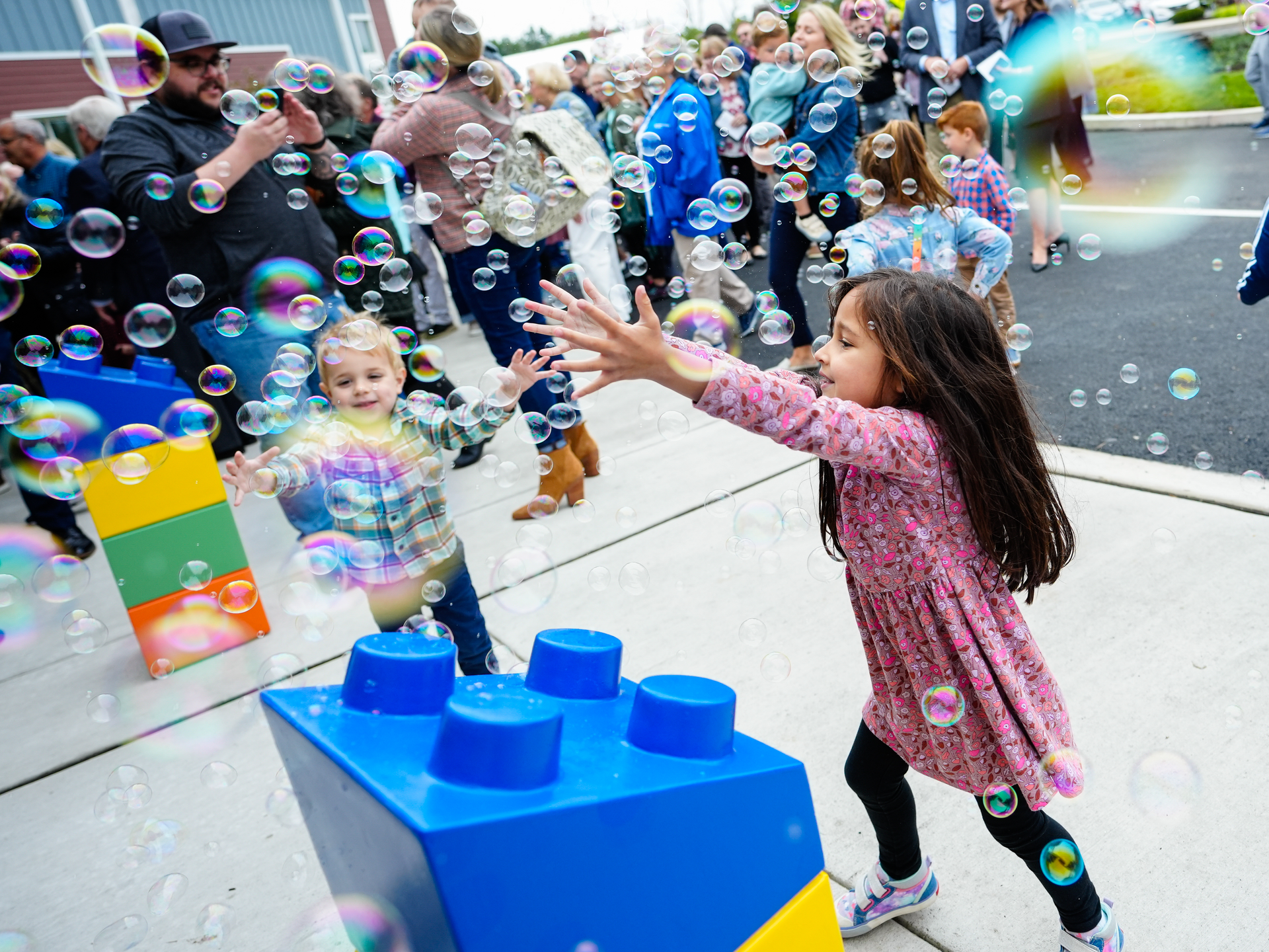 Children playing with bubbles outside Children's Village 