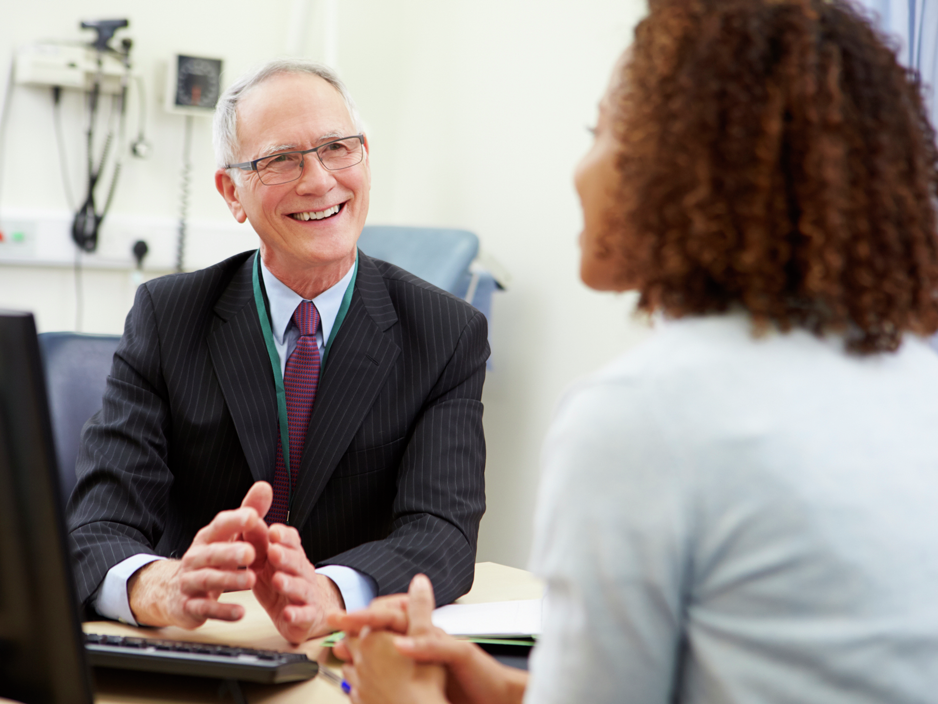 Consultant meeting with provider In office looking at each other smiling