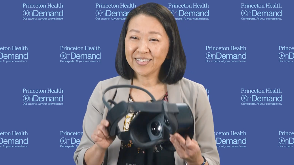 Yuko Martin, MA, holding a virtual reality headset.