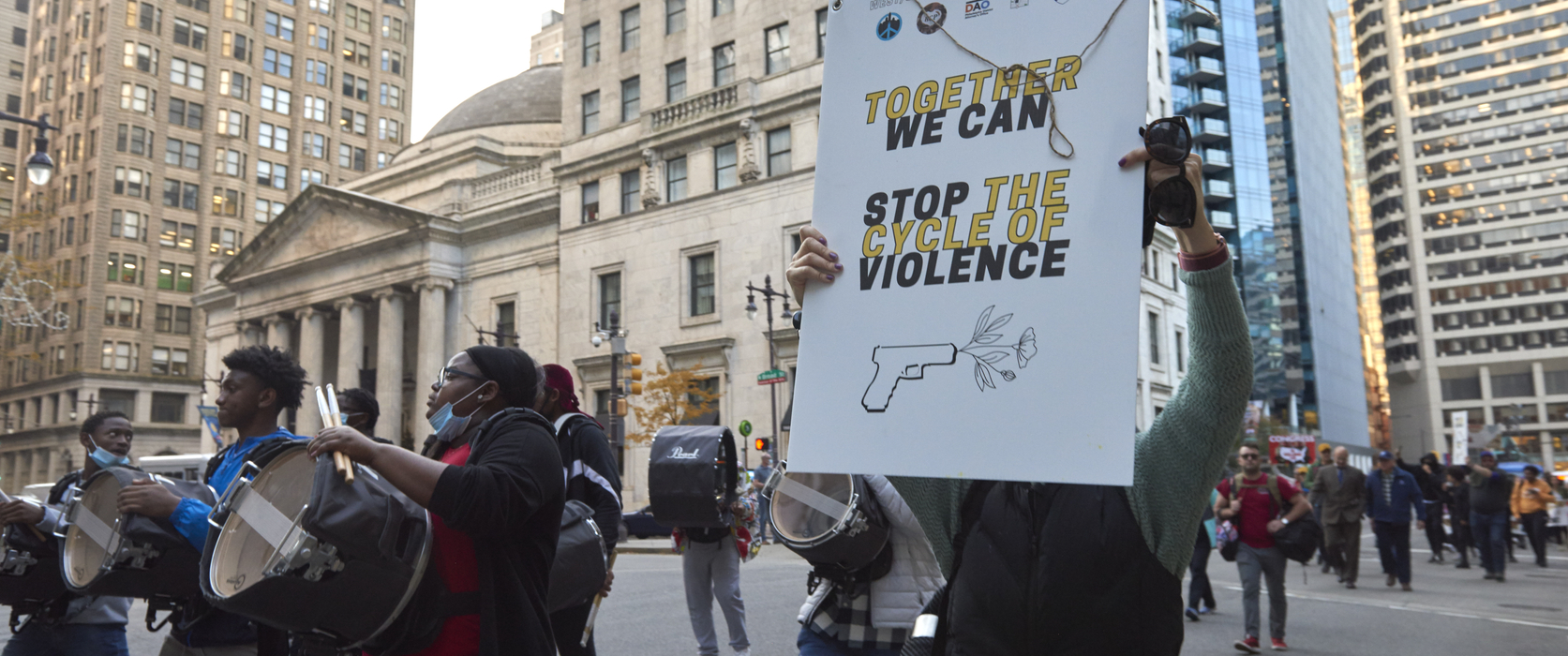 protestors on a march against gun violence walk on Philadelphia streets holding signs