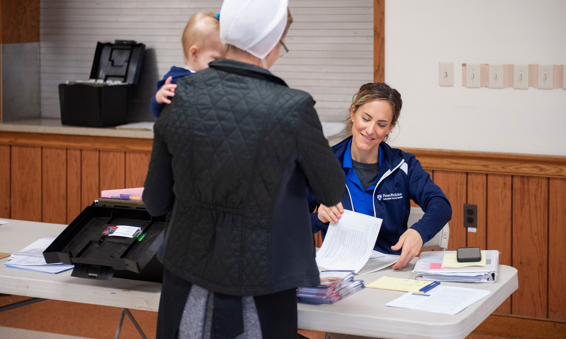 Jennifer N. Carter, a Lancaster General Health nurse, greeting a mother from the Plain Community, who is holding a baby.