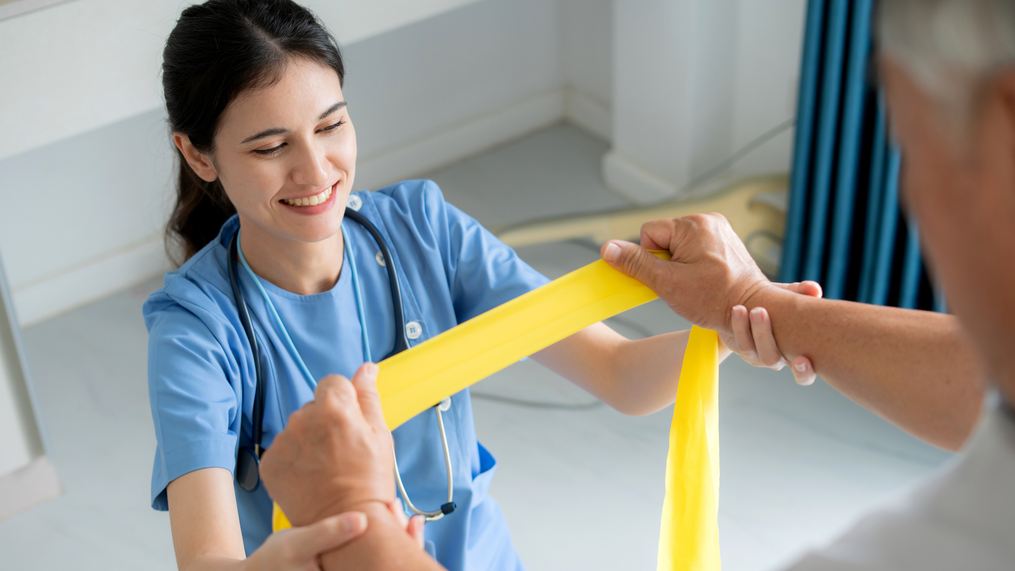 Therapist helping elderly patient with resistance band exercise.
