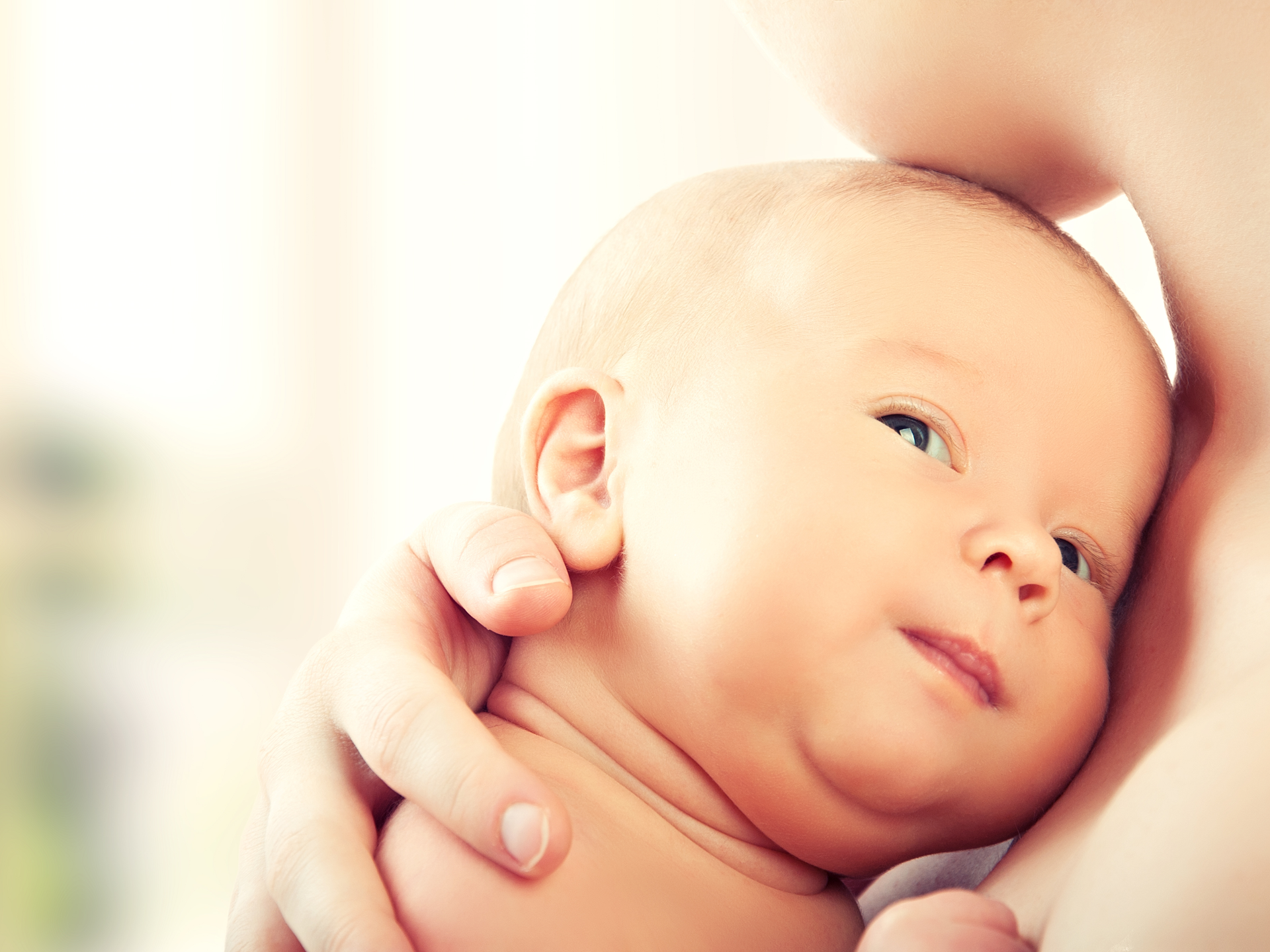 Close-up of a baby face against the mother's neck
