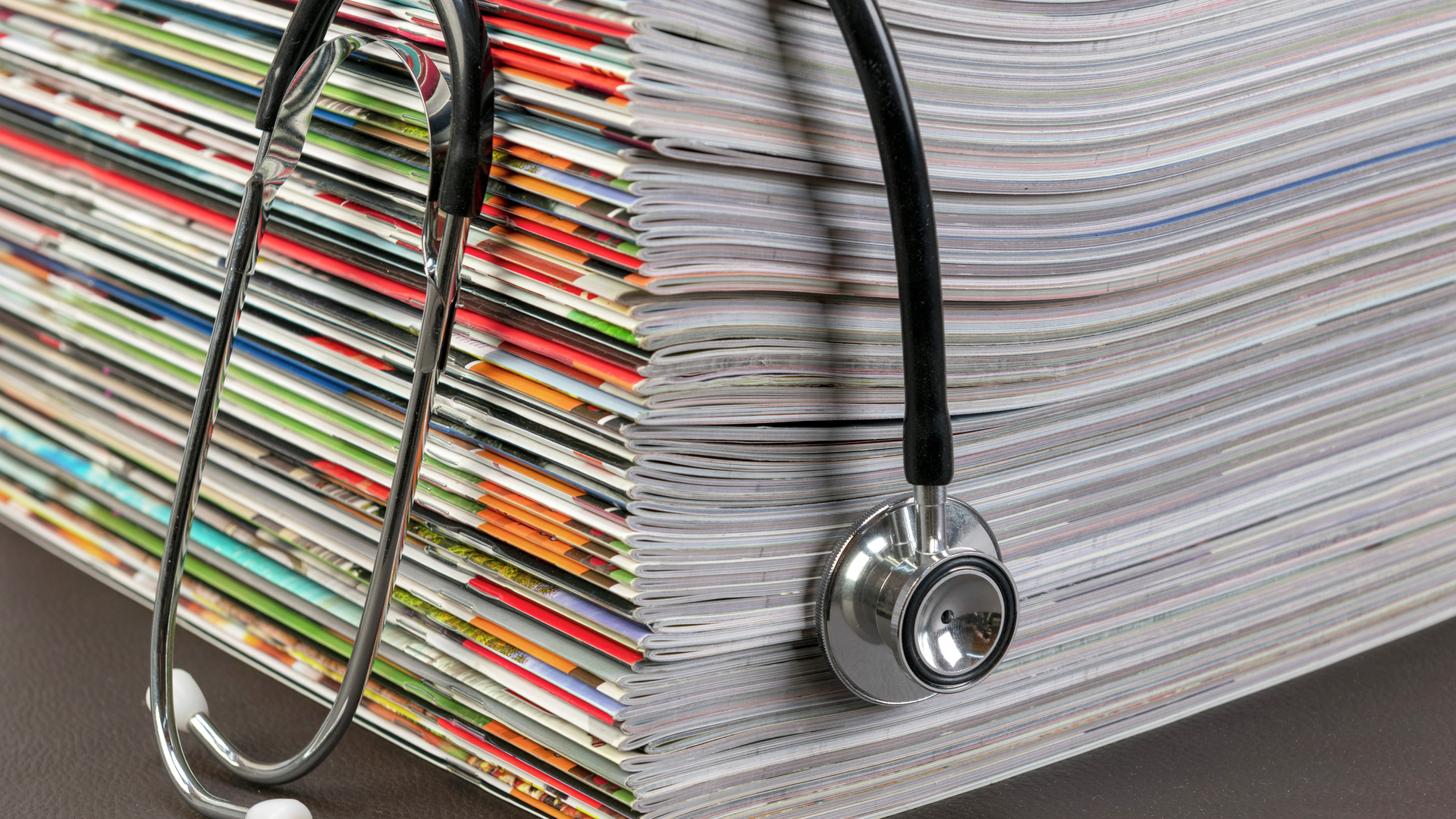 A stethoscope on a stack of medical journals