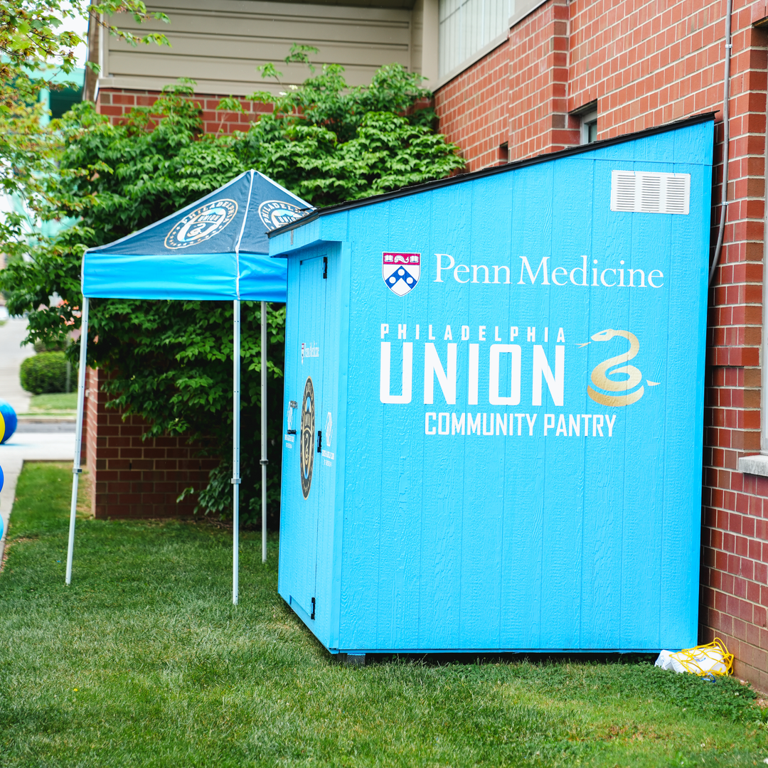 A teal shed with Penn Medicine and Philadelphia Union logos is the food pantry in Chester