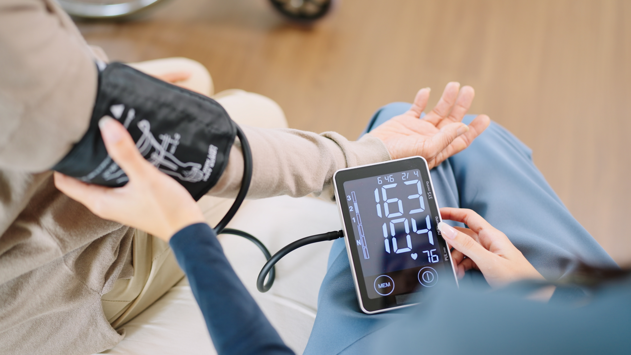 A nurse checks blood pressure monitor and heart rate monitor with a digital pressure gauge