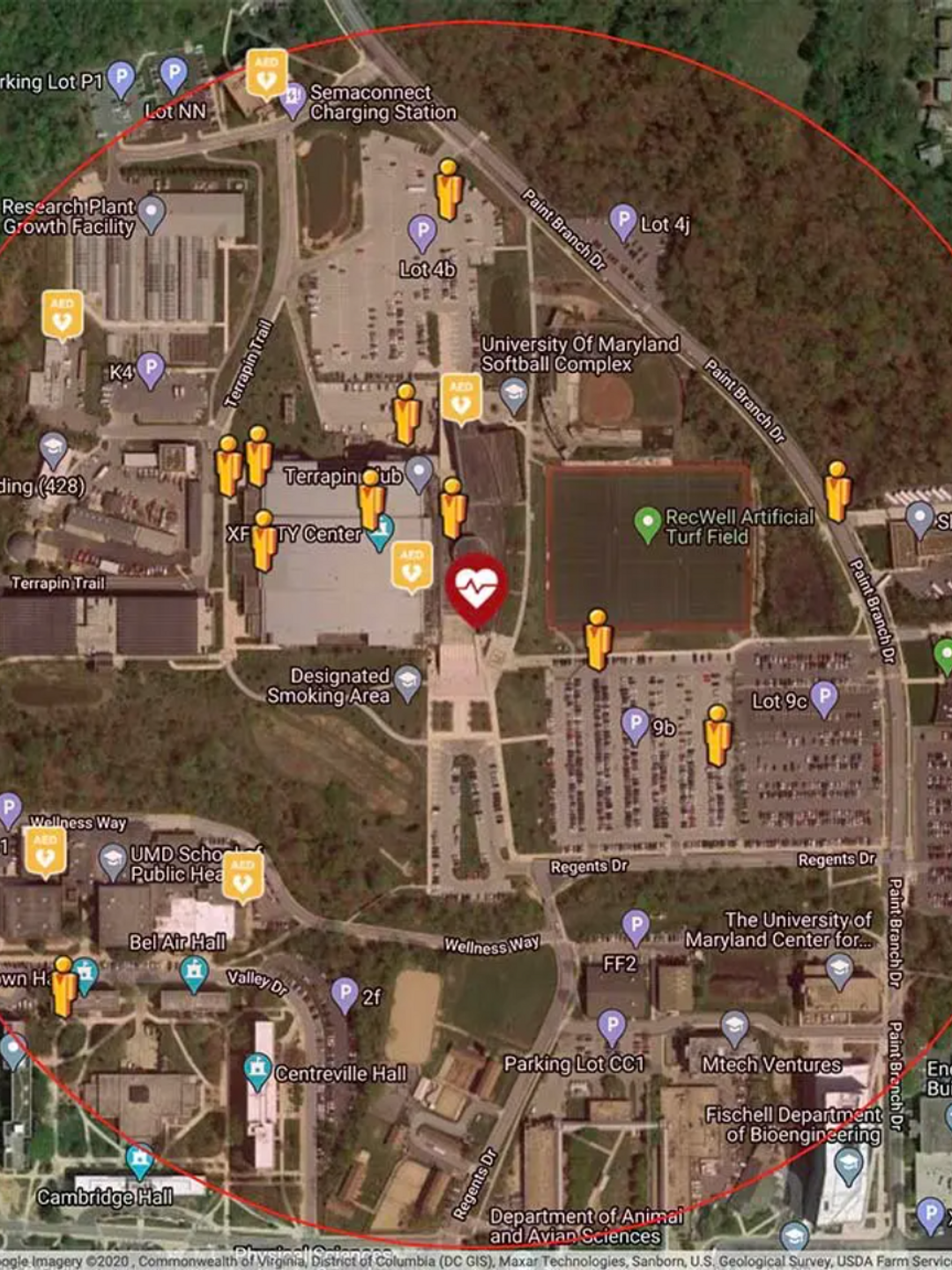 A satellite map image of an image that includes a school and commercial complex, with icons indicating the locations of app users and AEDs