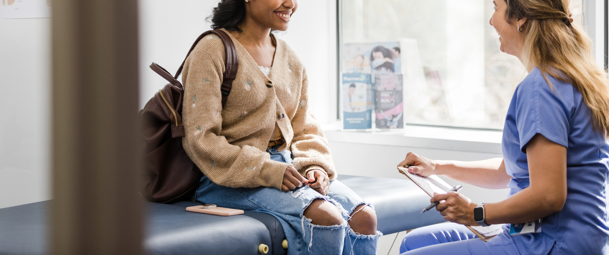Young adult female patient smiles while talking to a nurse 