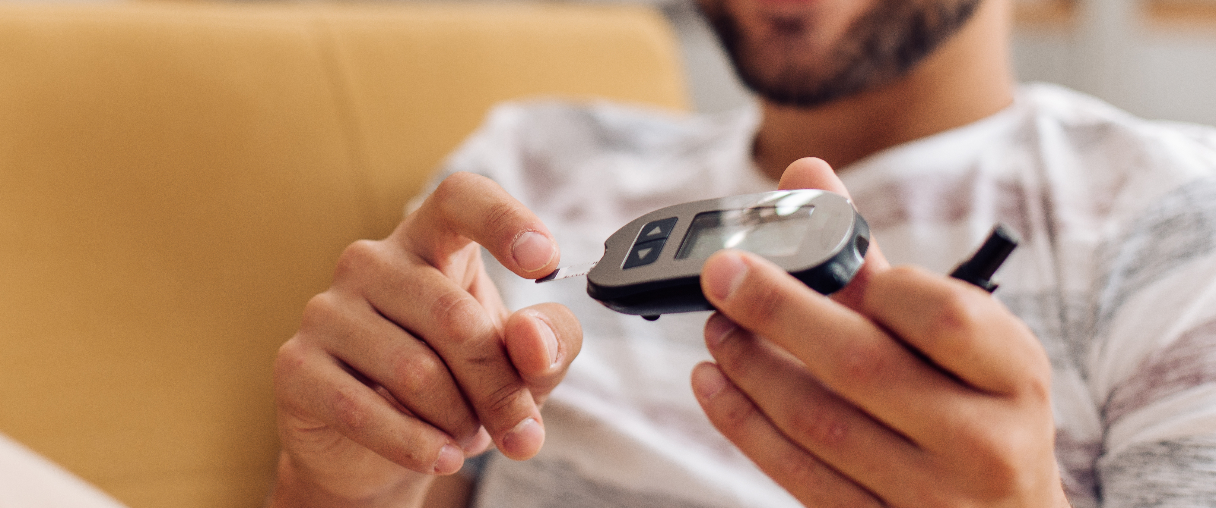 Young man measuring insulin level at home.