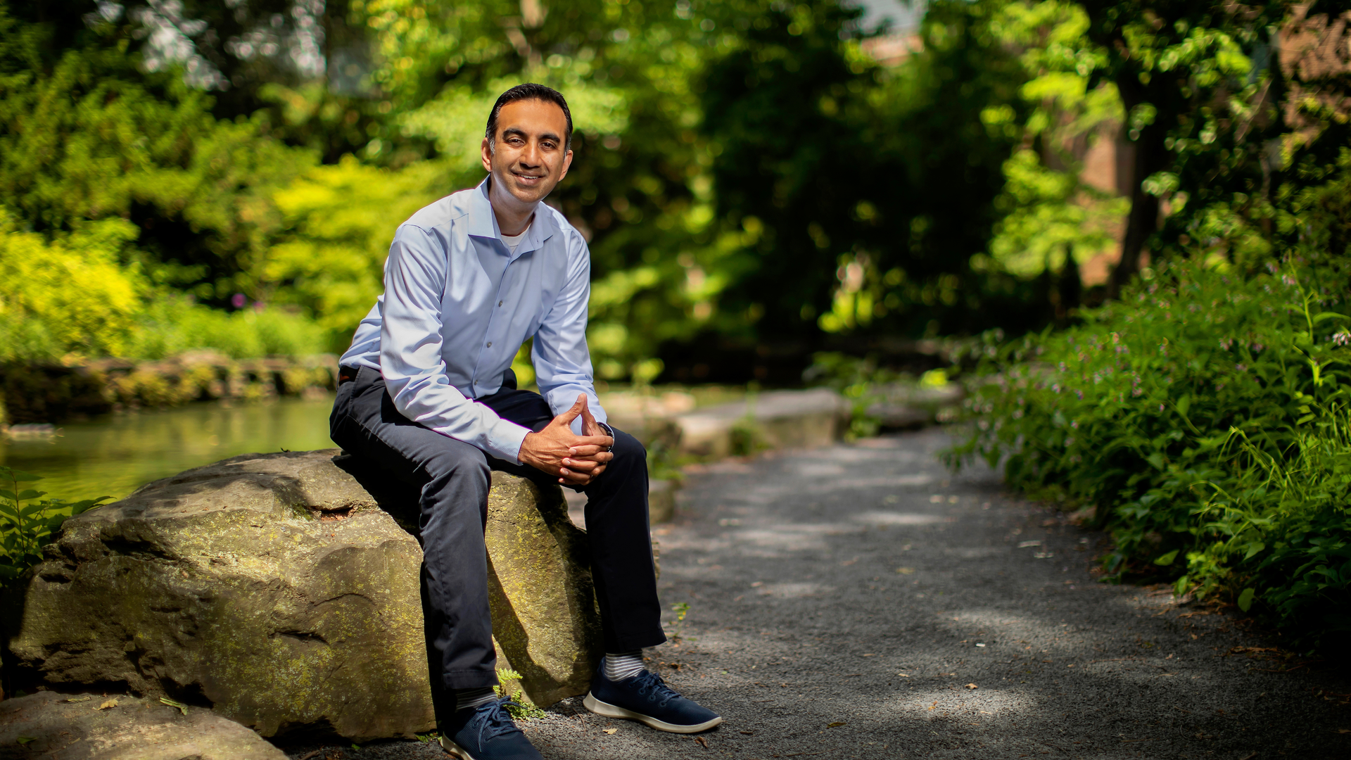  Amol Navathe, MD, PhD, sitting in a park with trees in the background