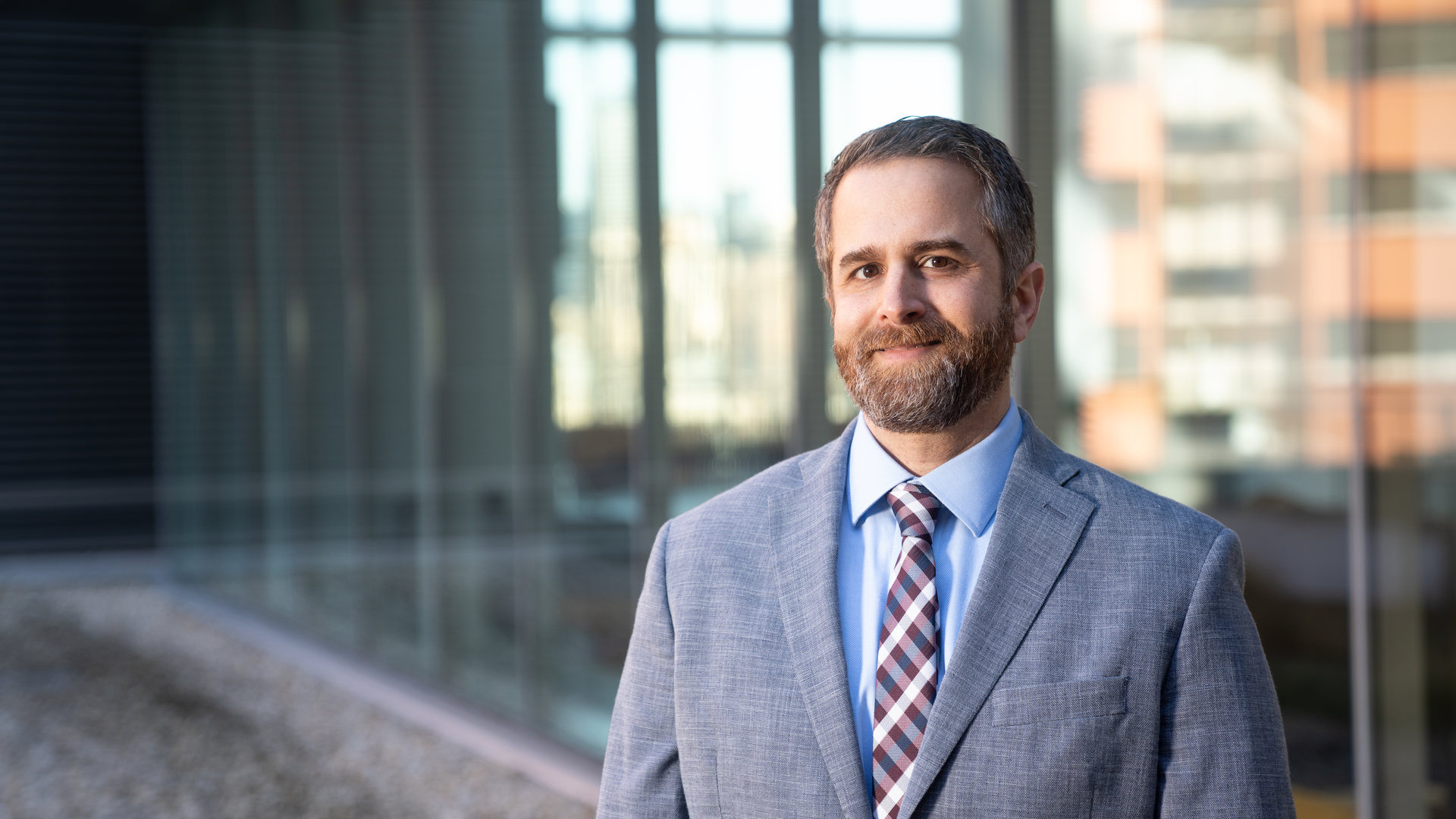 Misha Rosenbach MD standing outside in business attire, smiling