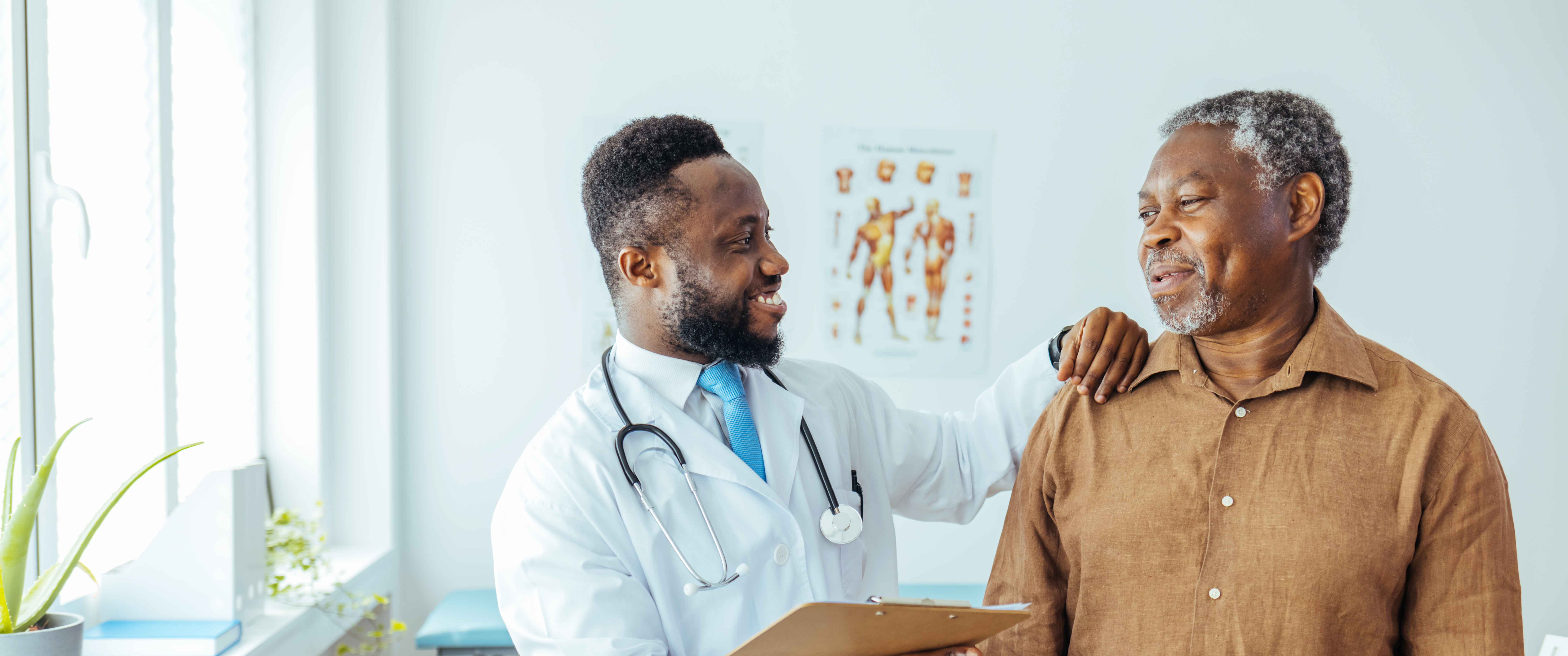 African American patient smiling with doctor in examination room