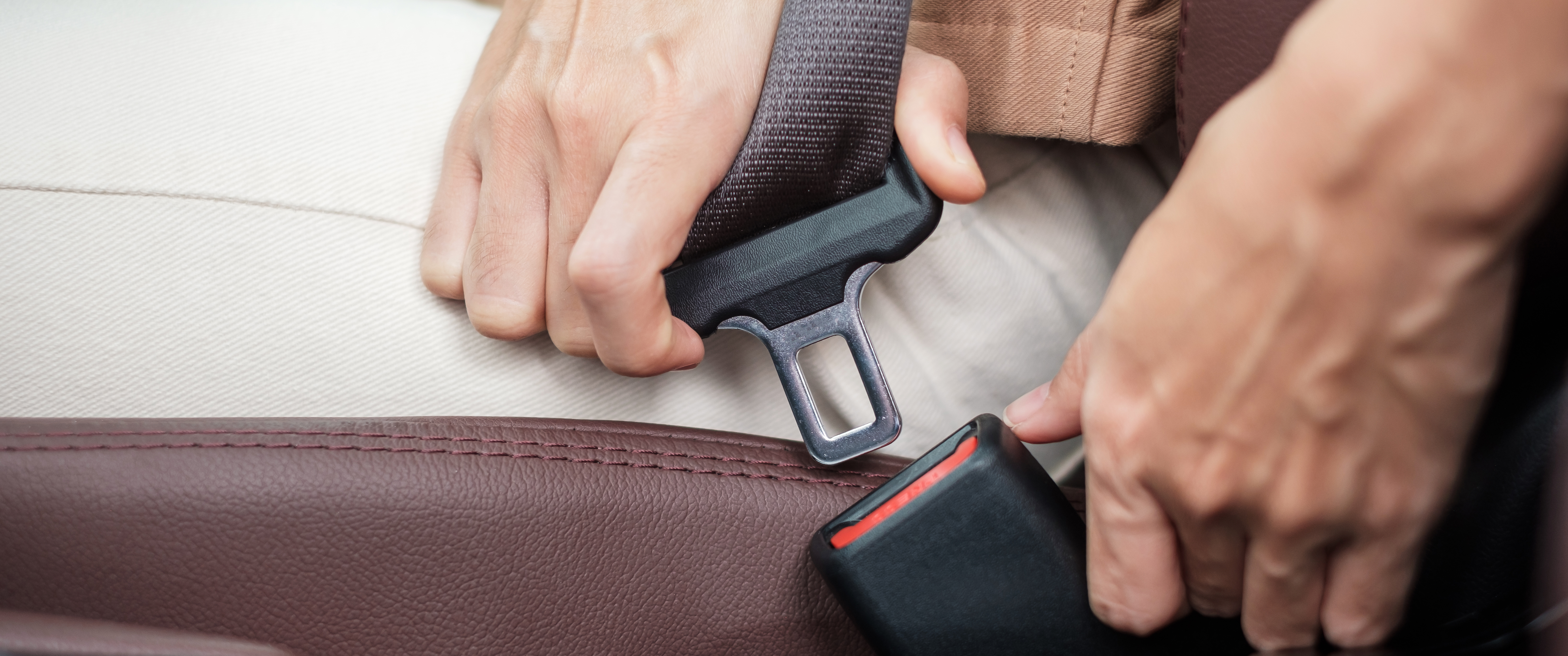 Close-up of person fastening seat belt in car