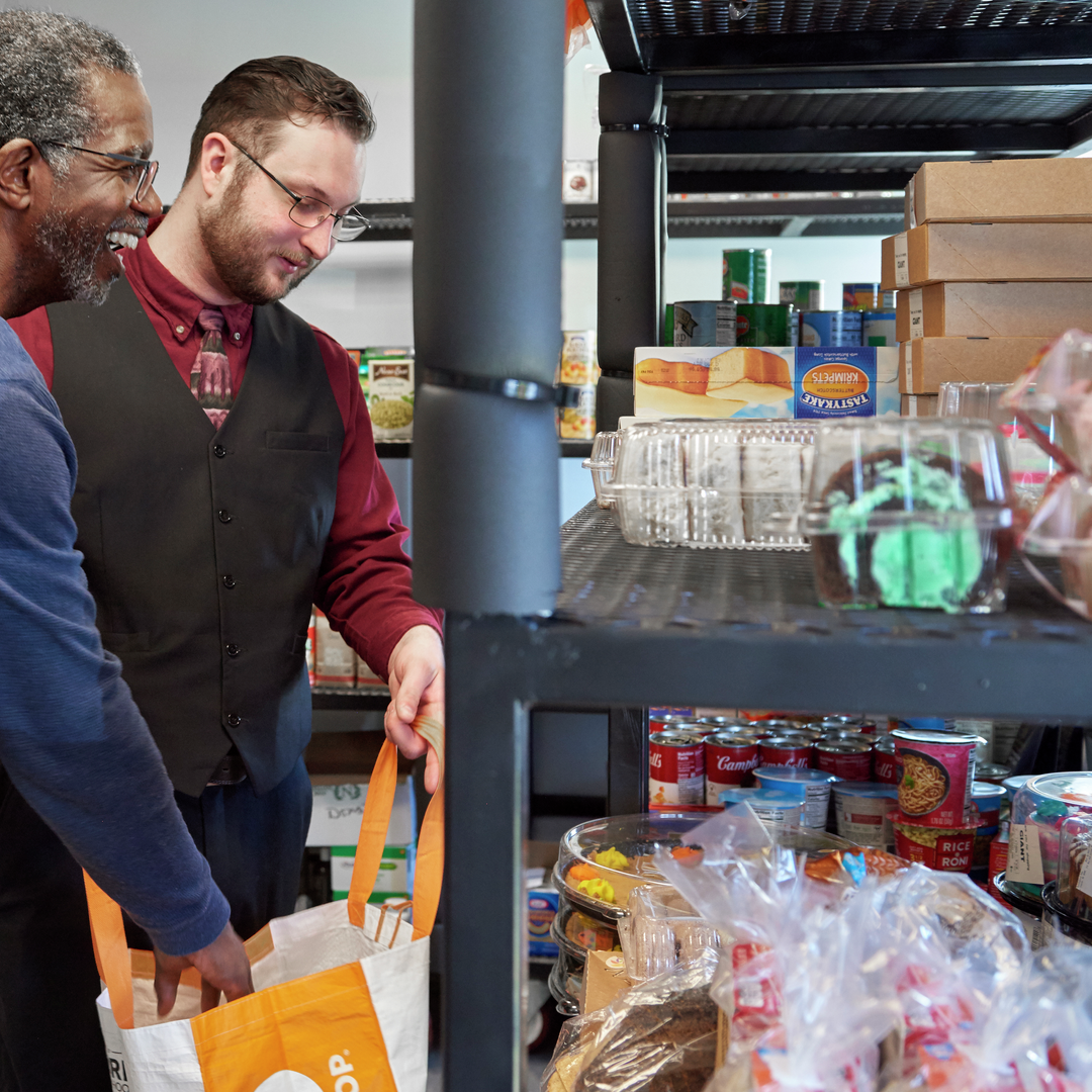 Timmy Nelson and Christopher Moore pack food into a shopping bag