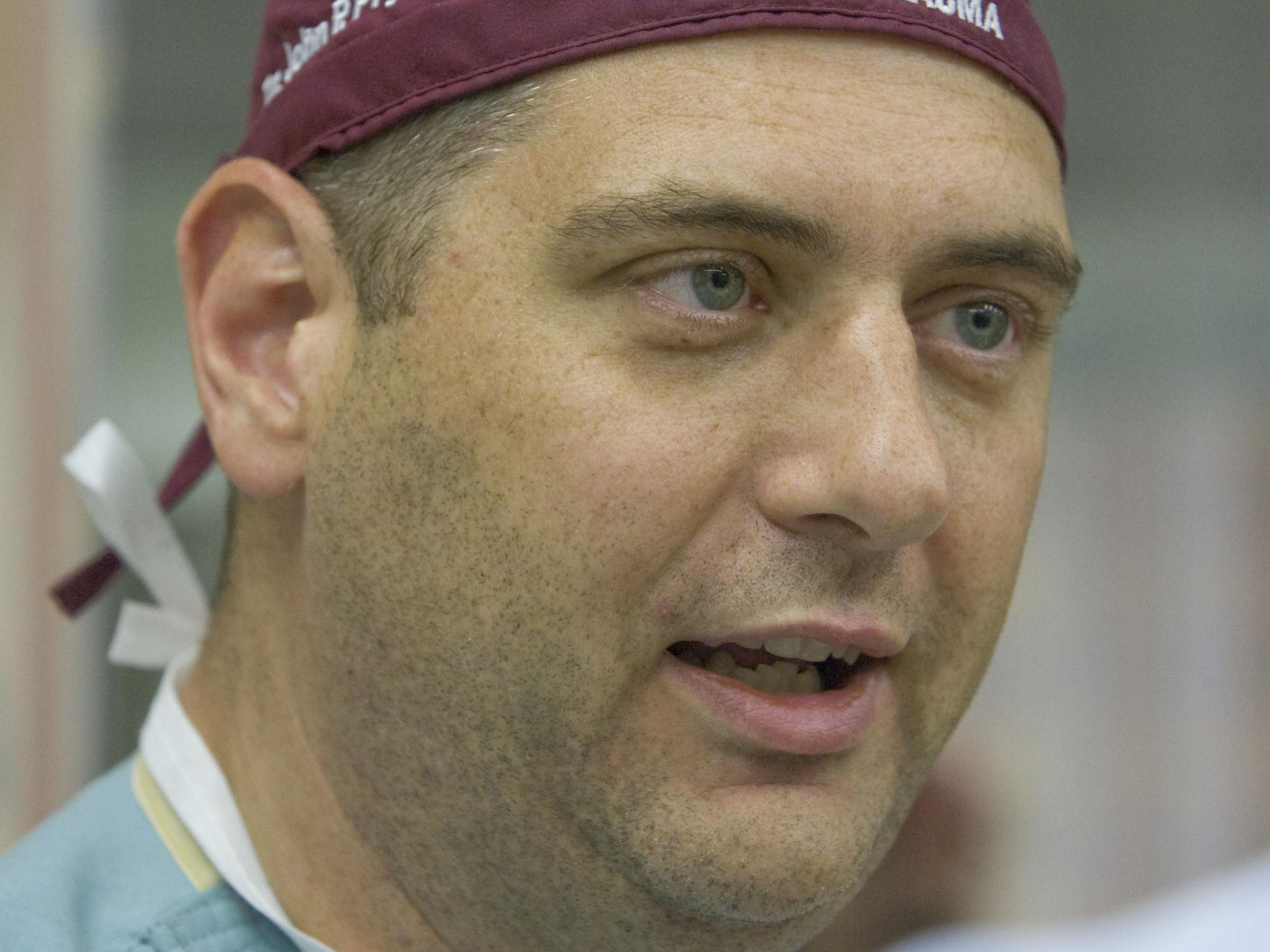 Close-up candid photo of the face of John P. Pryor, MD, wearing scrubs and a surgical cap