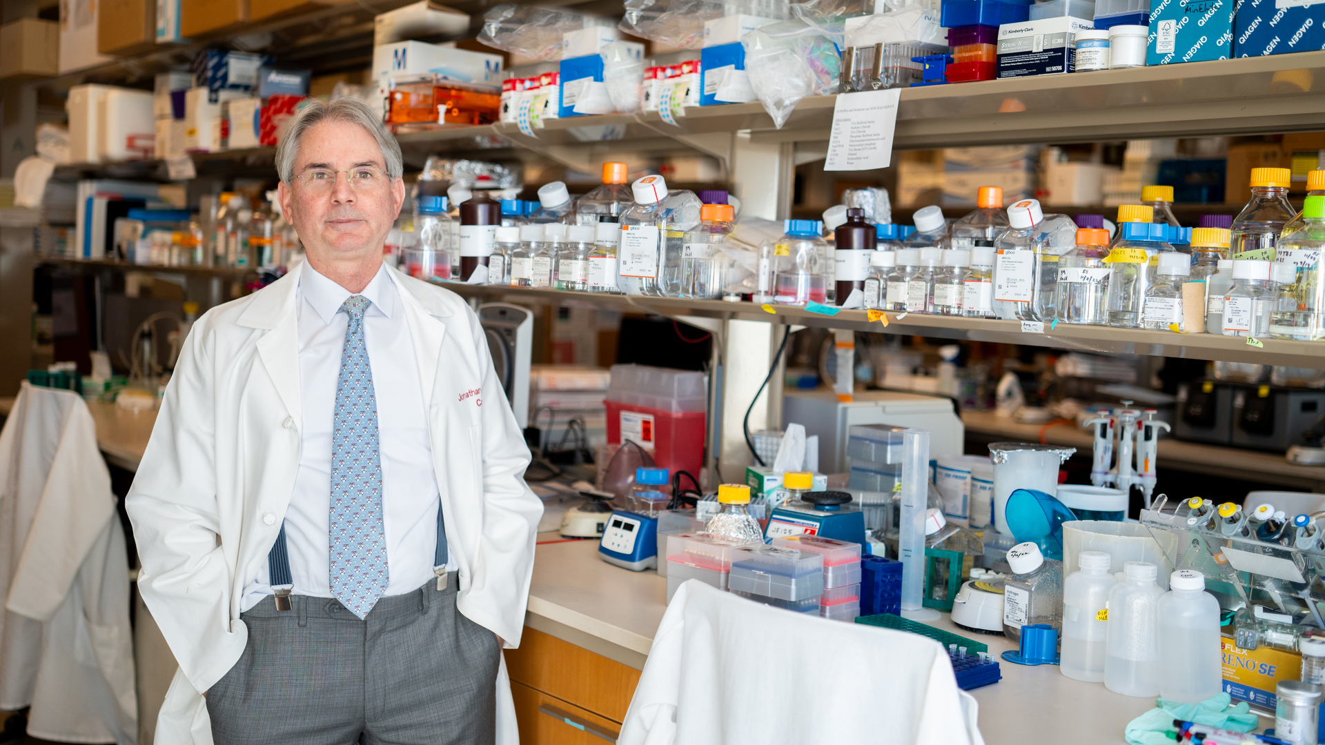 Jonathan A. Epstein, MD, wearing a lab coat, standing in front of a lab bench