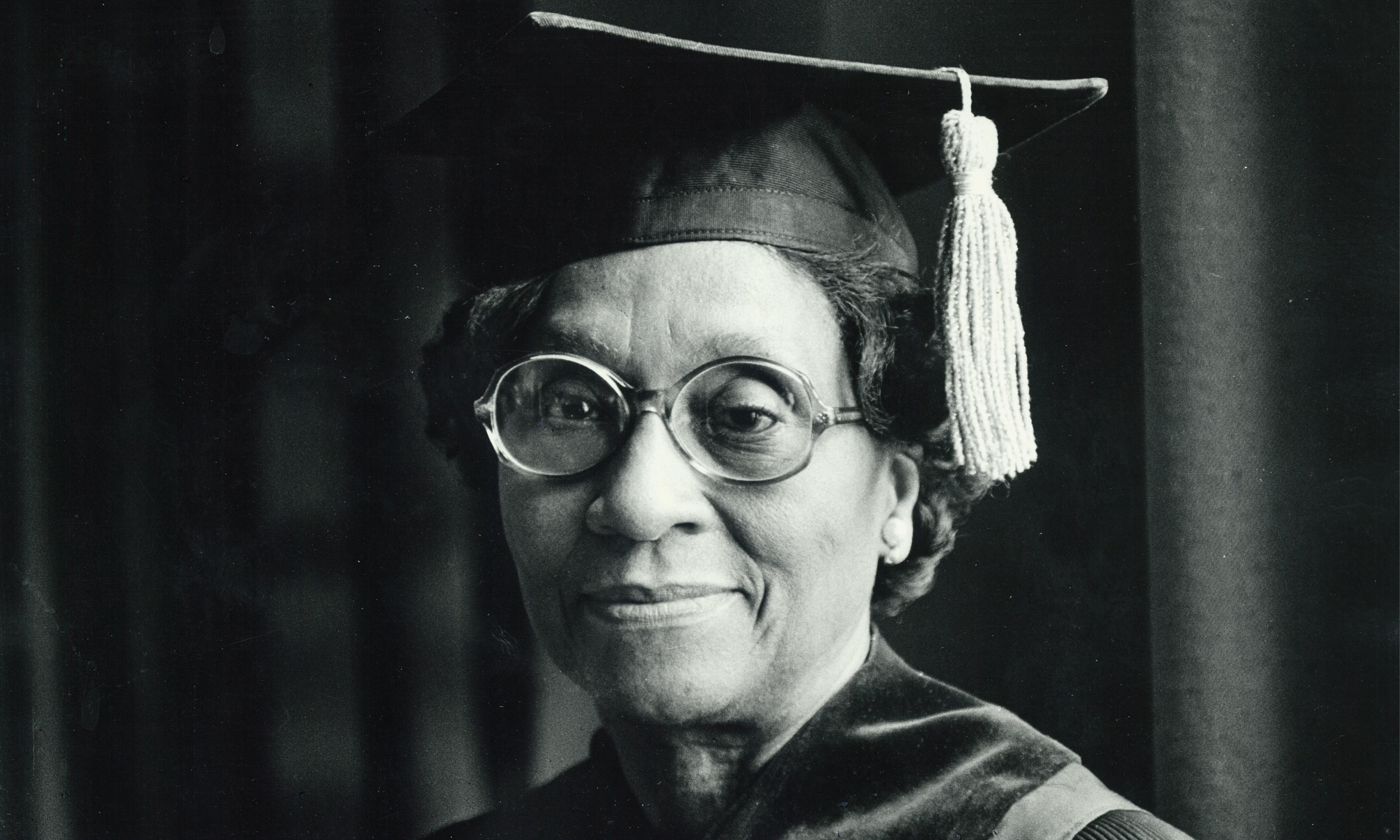 A black and white photo of Helen O. Dickens wearing graduation regalia