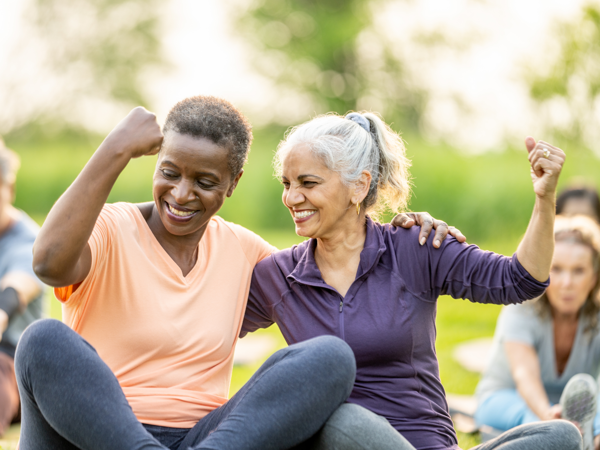 A group of senior individuals engaging in outdoor fitness activities, enjoying companionship and promoting health. The image captures smiles, togetherness, and active living in a beautiful natural setting.