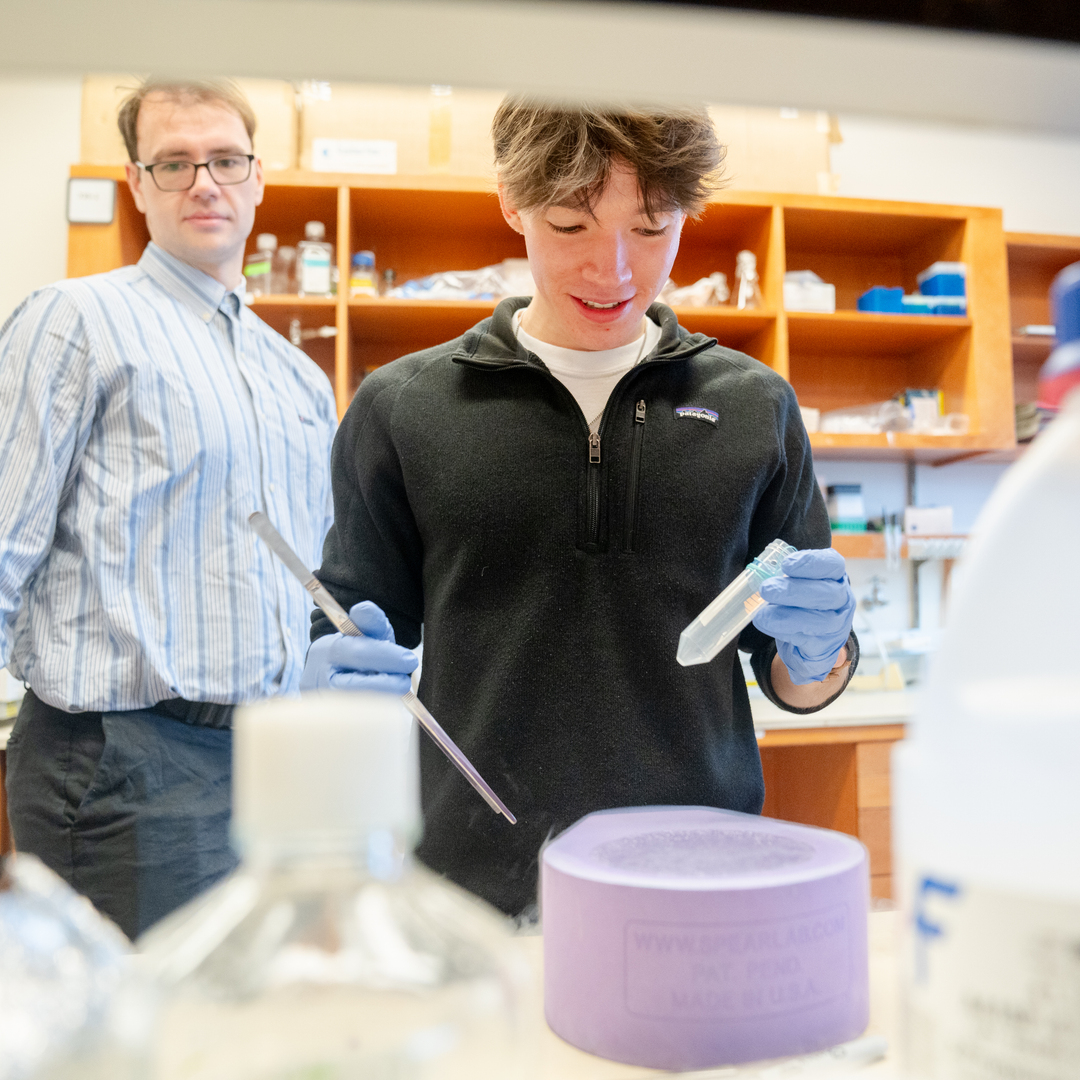 Jonas Cook works with a frozen sample in the lab as Nicholas Palmer watches