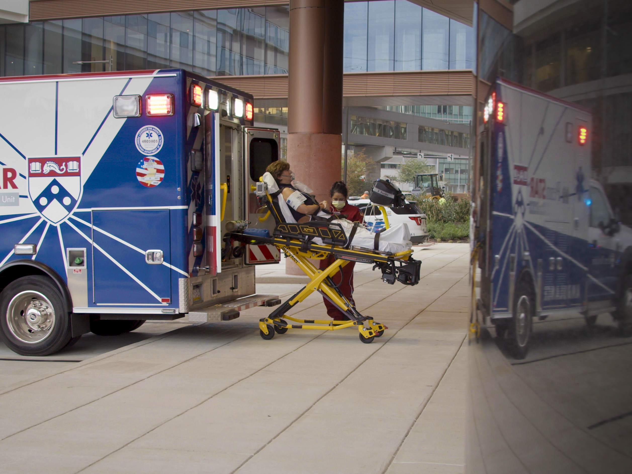 Patient on gurney being removed from PennStar ambulance at Clifton Center ambulance bay. 
