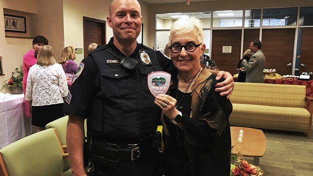 Suzan H. Arnold holding patch and posing with  Lititz Borough Police Department police officer