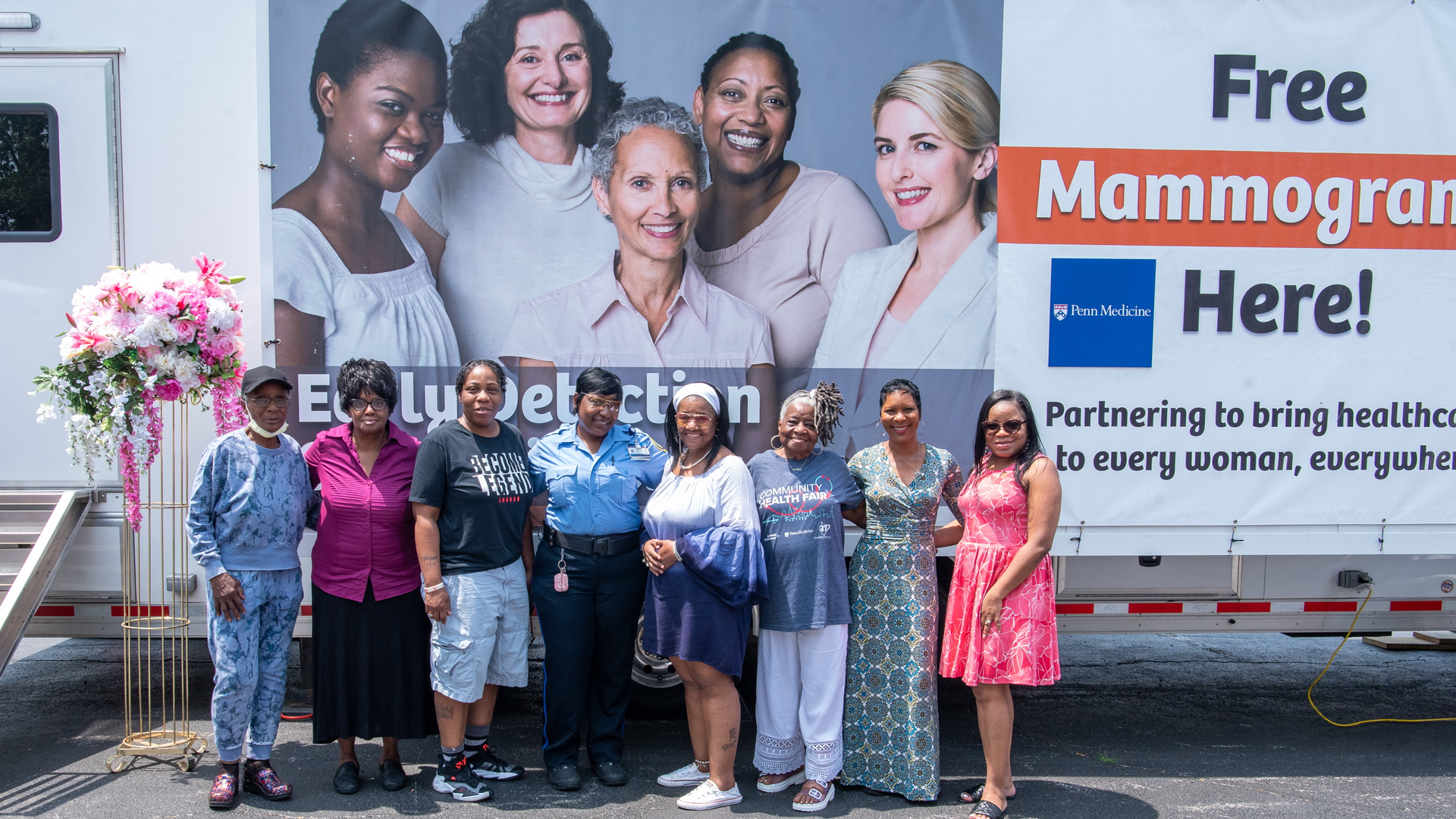 Members of the community pose in front of mammogram screening trailer