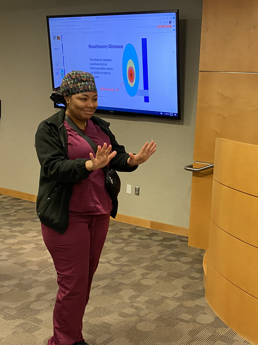 Two nurses, standing and facing each other, participate in a de-escalation training exercise