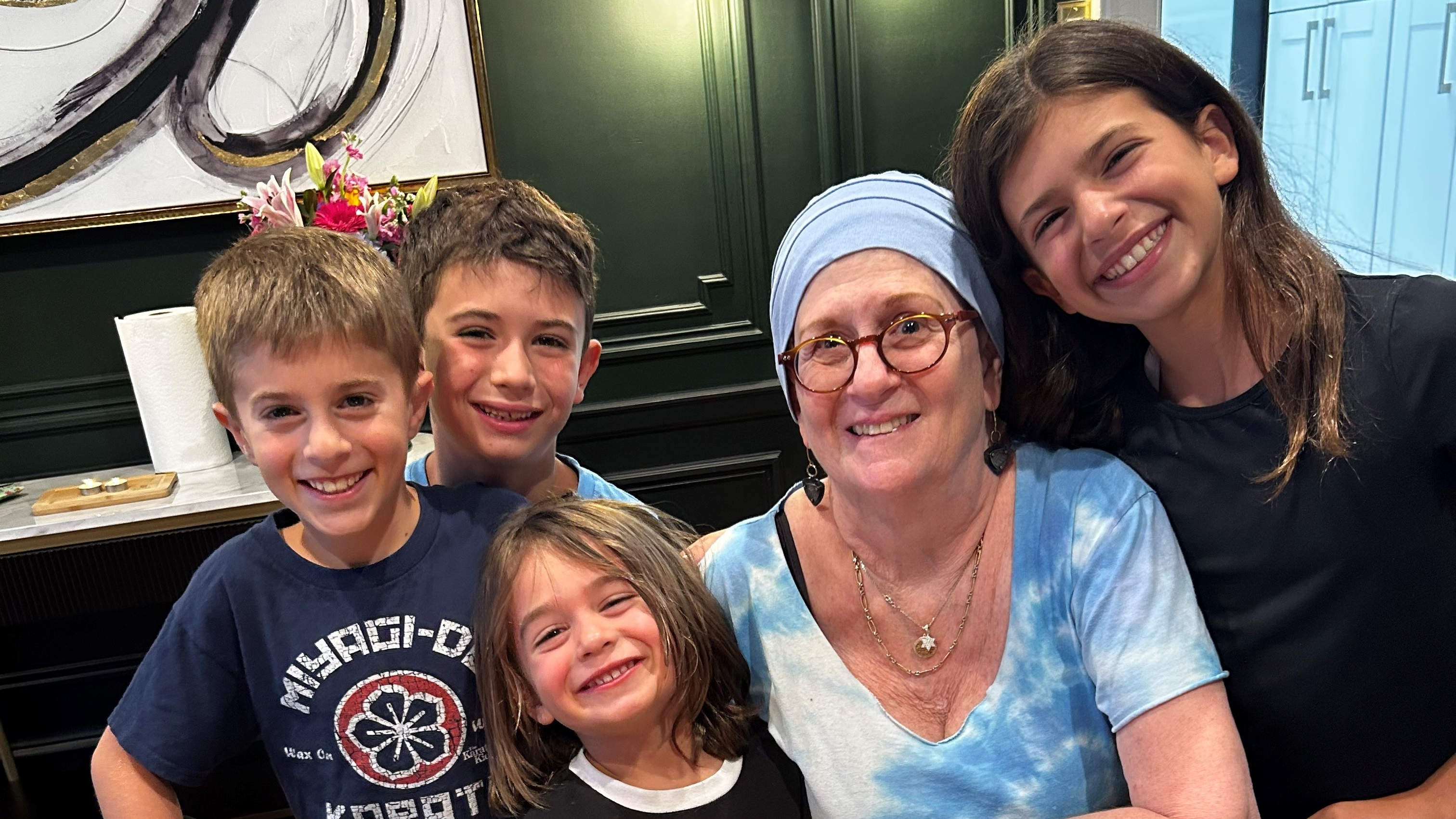 Lynn Oxenberg smiles with her grandchildren and 73rd birthday cake that reads, "Happy Birthday Bubby"