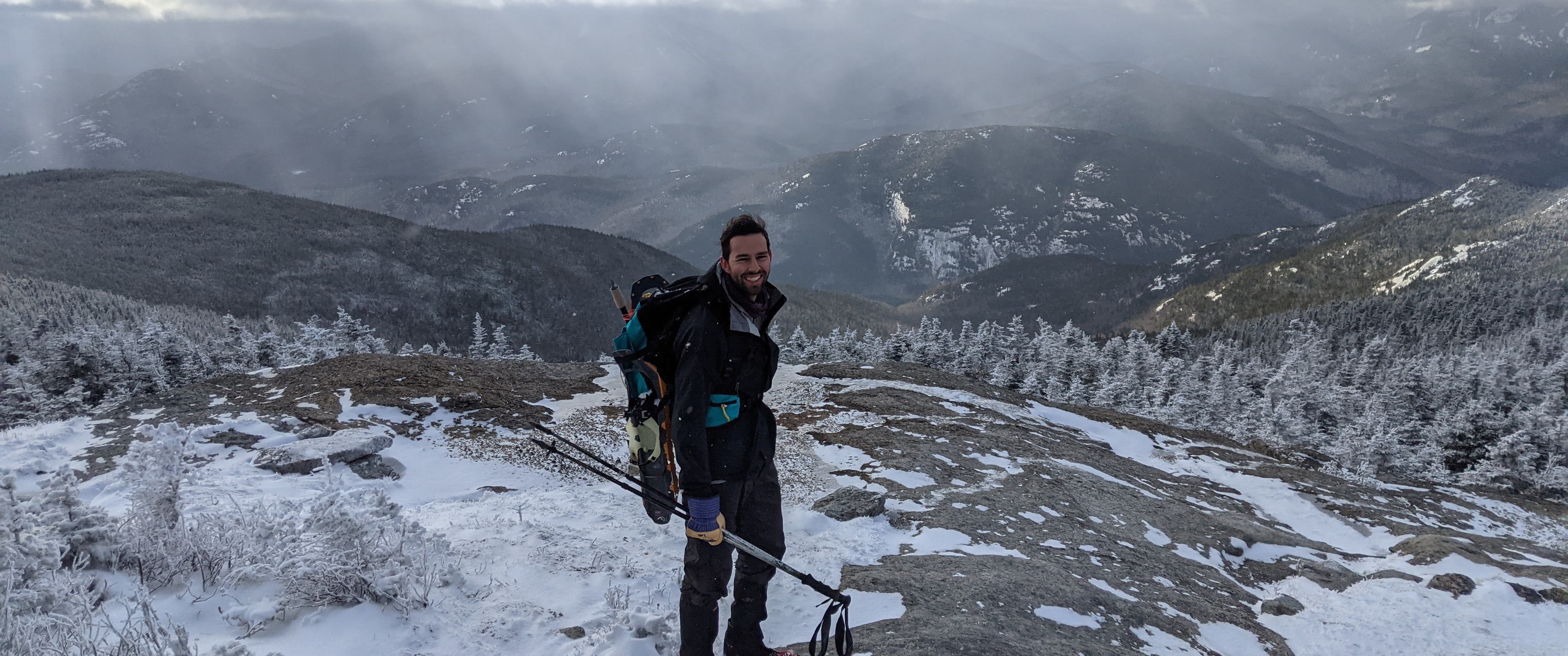 Chris Baccash on a hike with mountains in the background