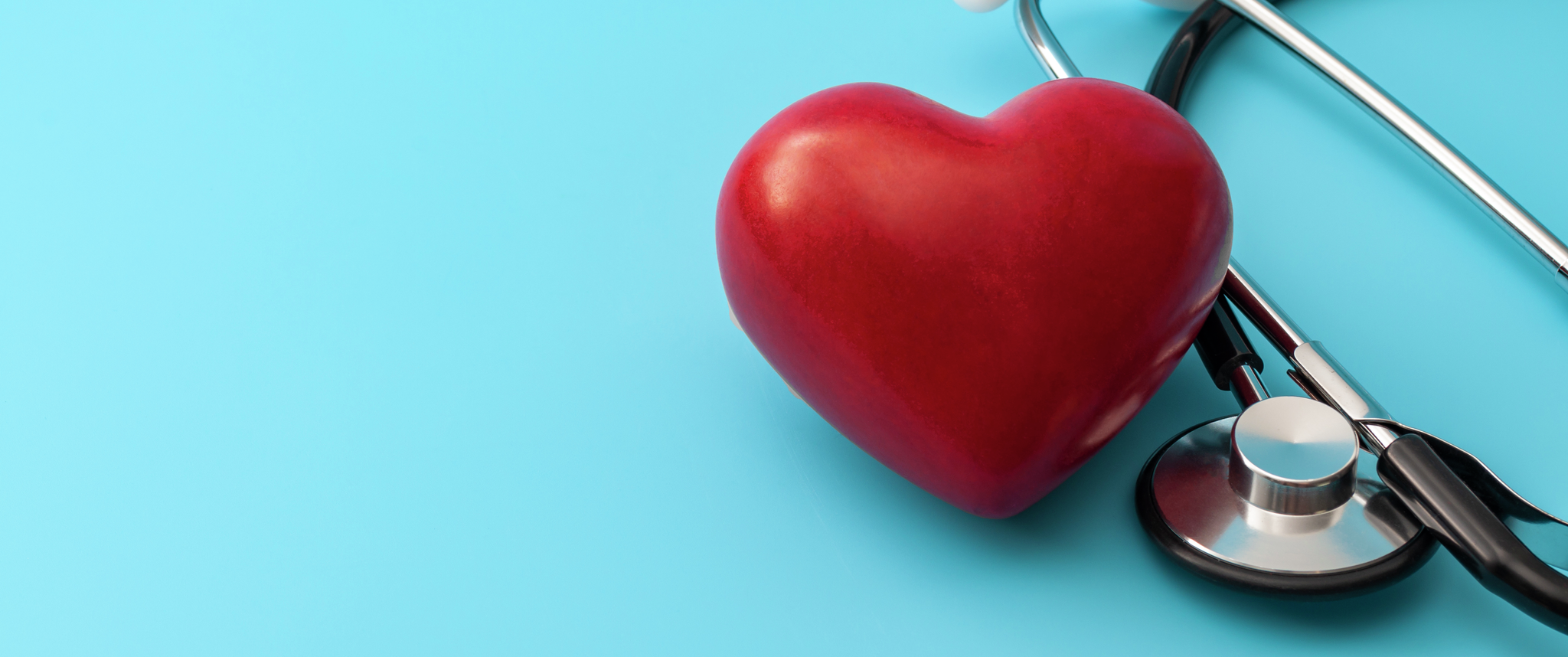 Red heart and stethoscope isolated on blue background