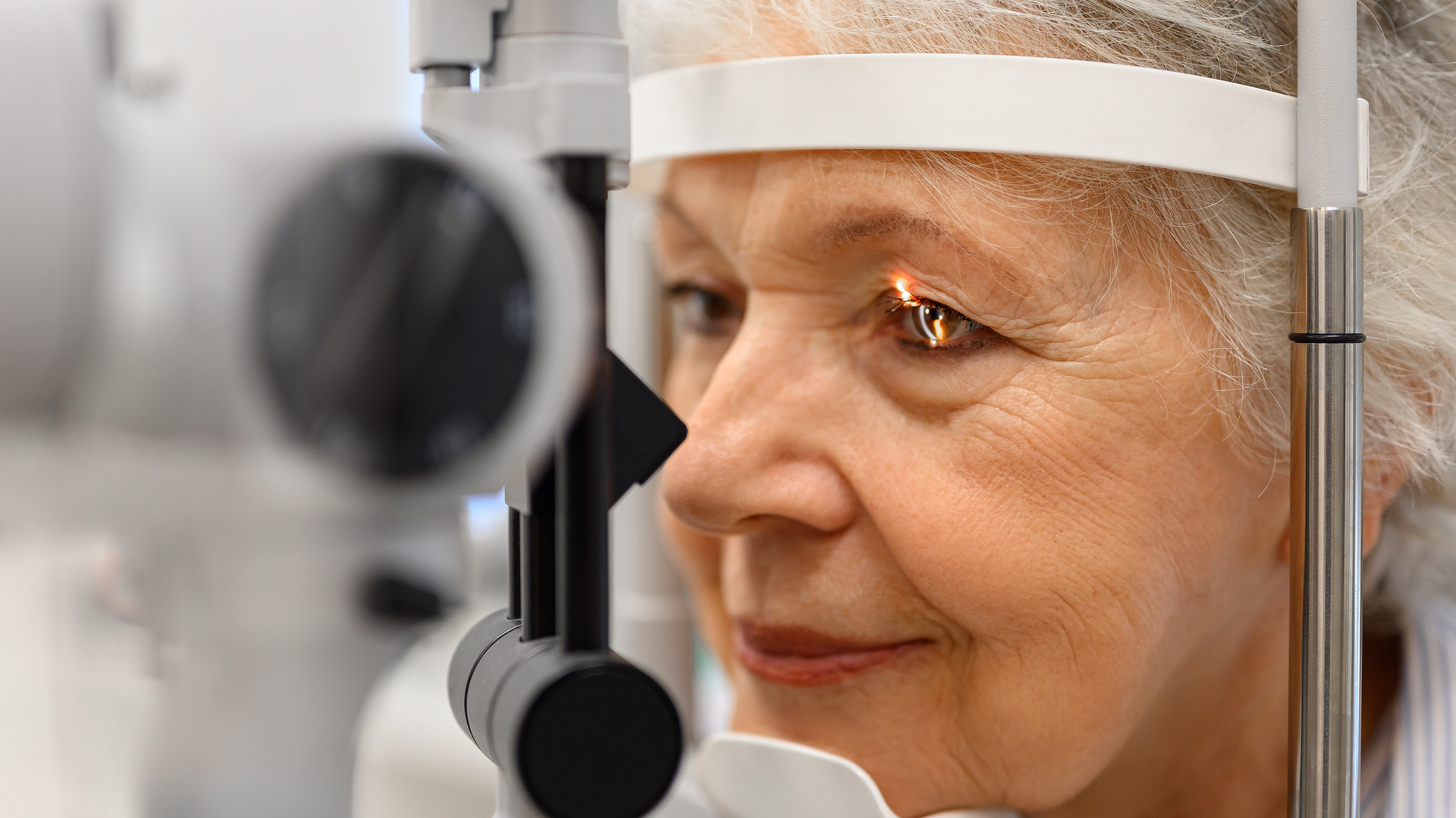  Close-up of mature patient undergoing detailed eye examination.