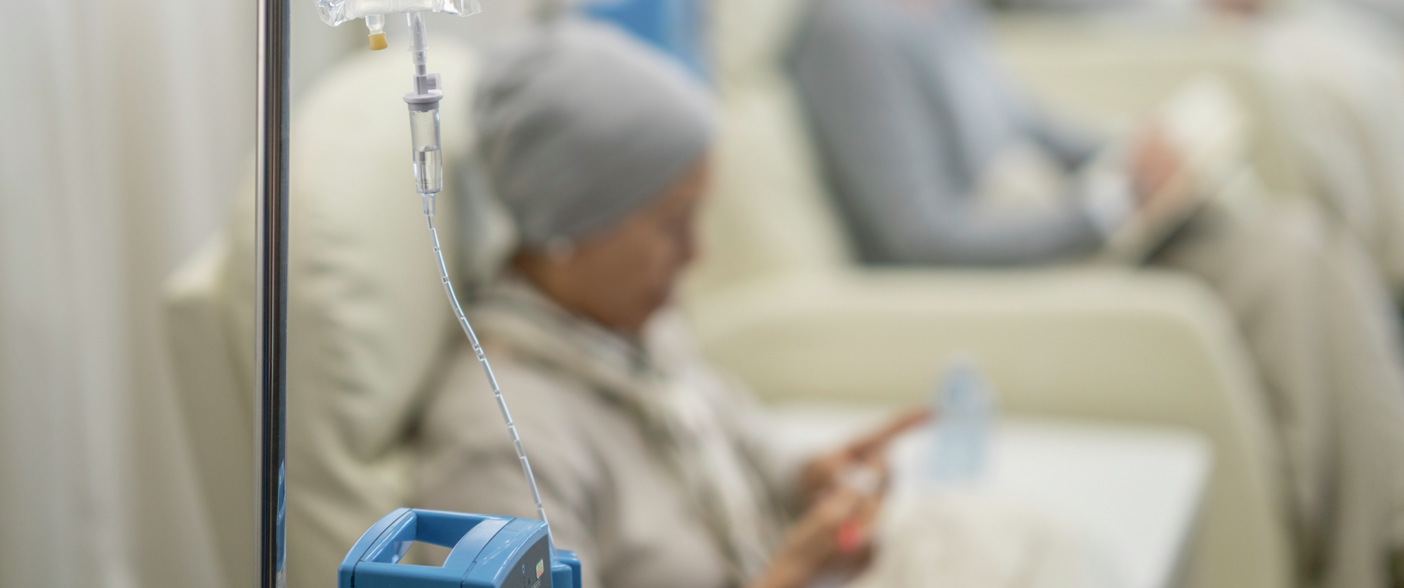 Three patients sit while receiving chemotherapy