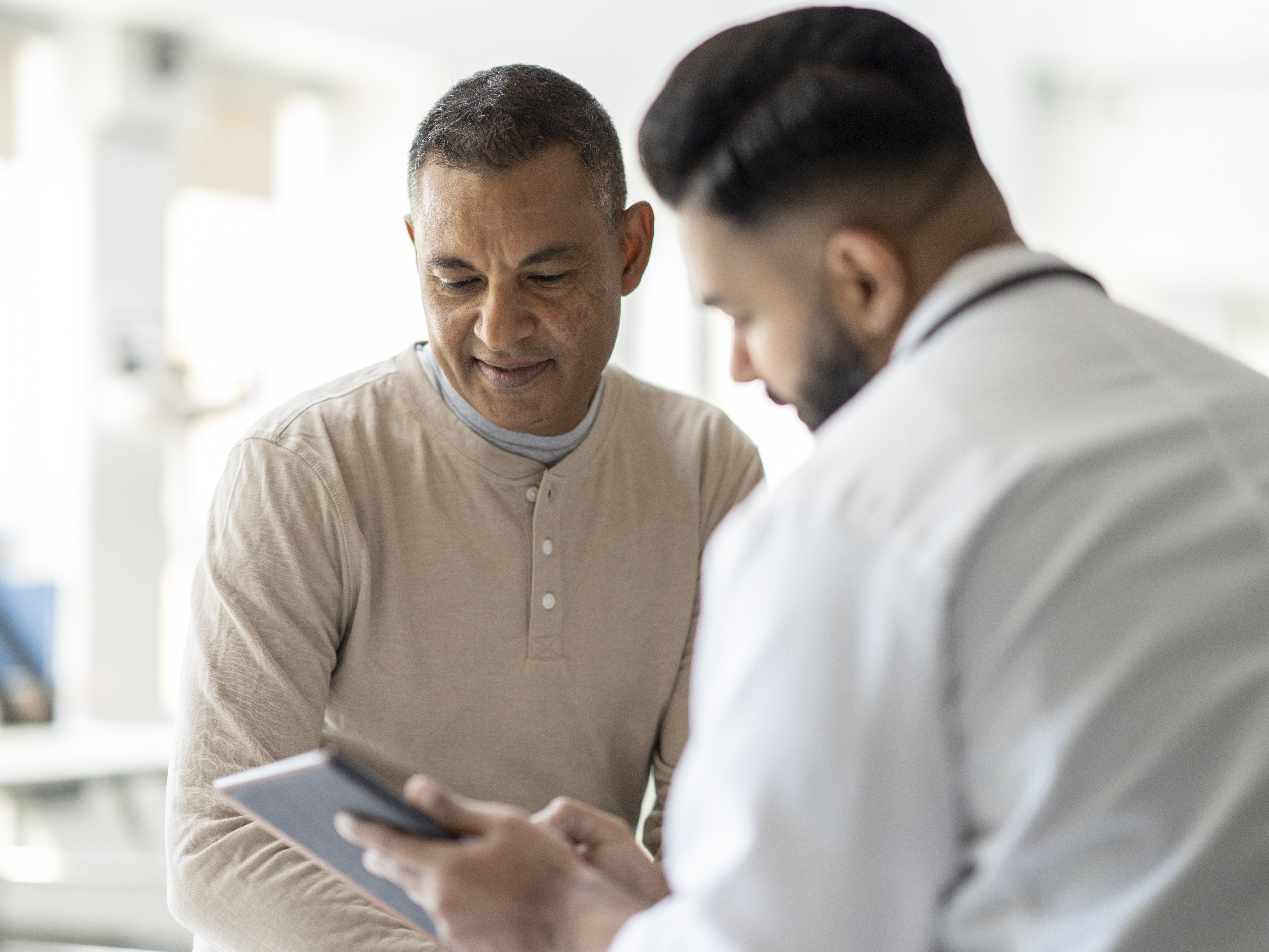 Male patient reviewing test results with doctor.