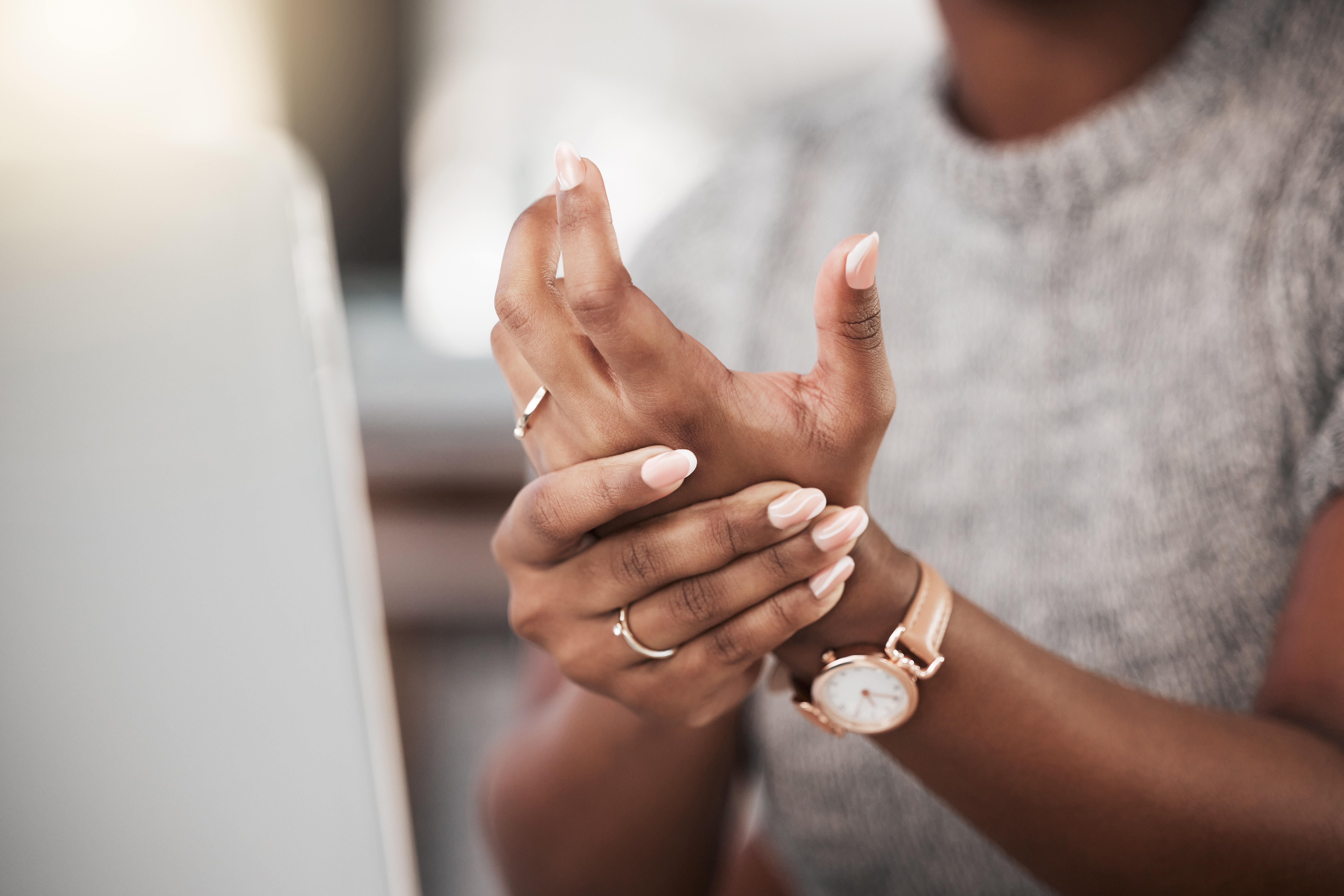 Businesswoman experiencing wrist pain while using a laptop
