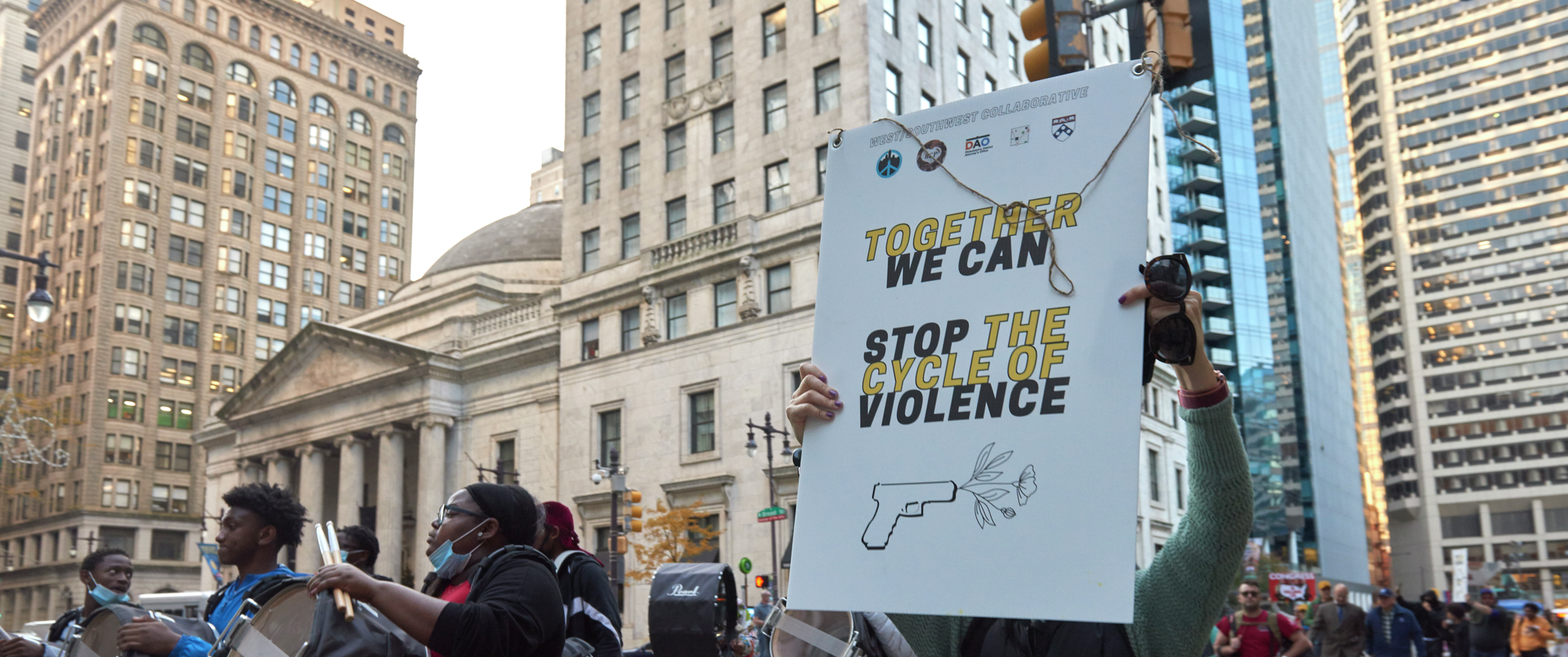 Protestors on a march against gun violence walk on Philadelphia streets holding signs