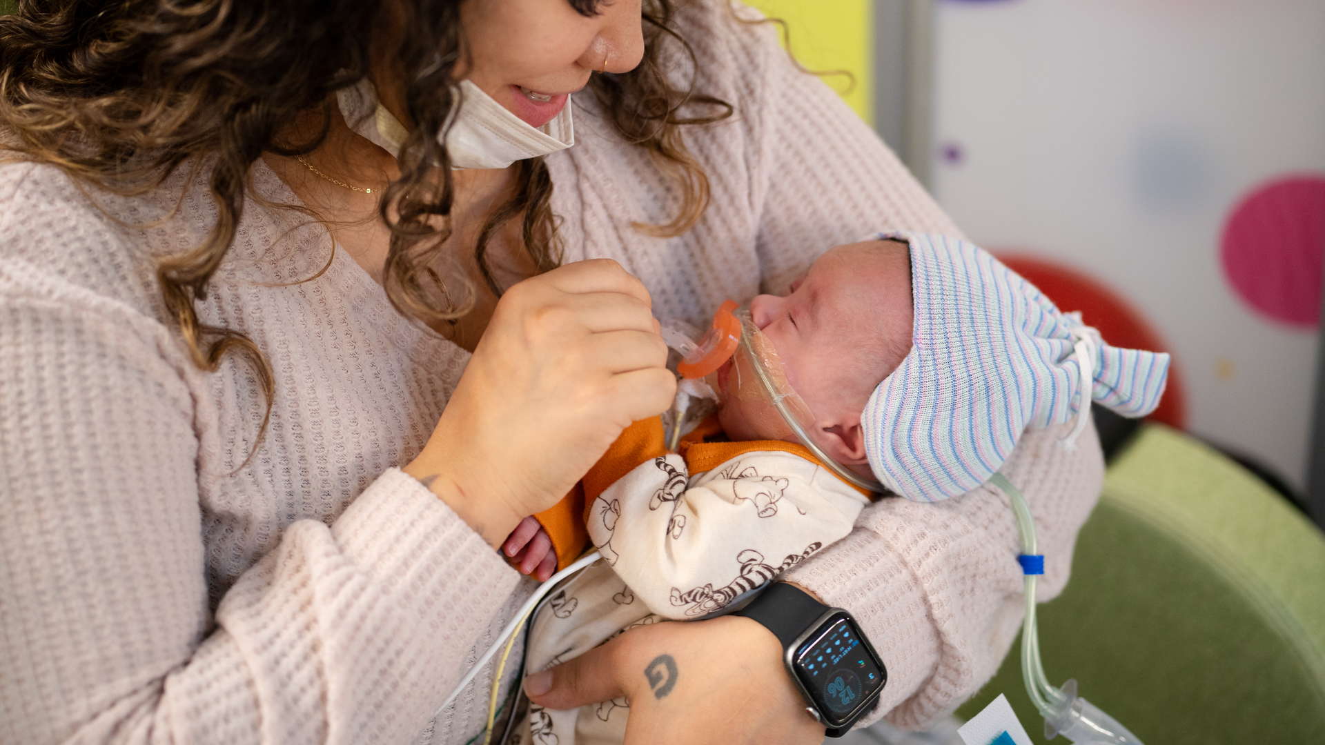 Pamela Collins holds her son, John, as he wears the Sonura Beanie