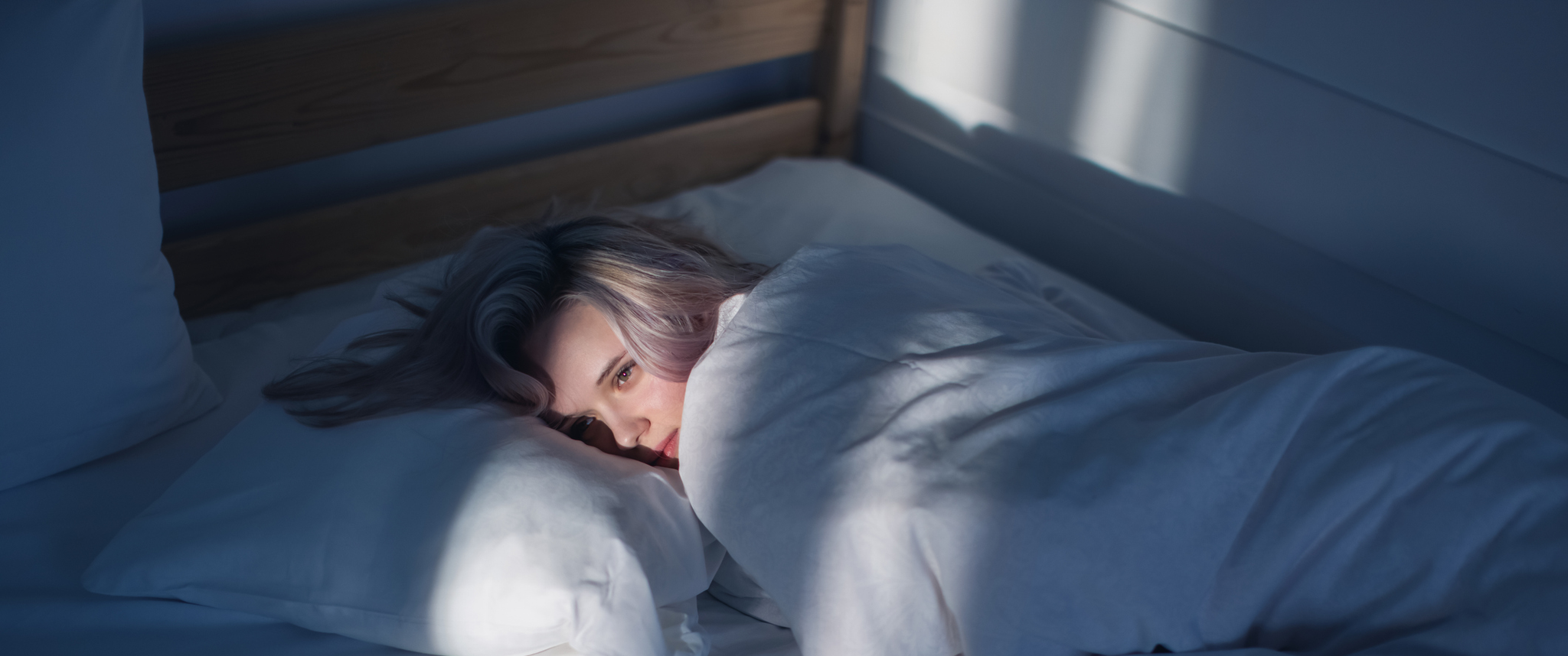 A woman lying on a bed, unable to sleep