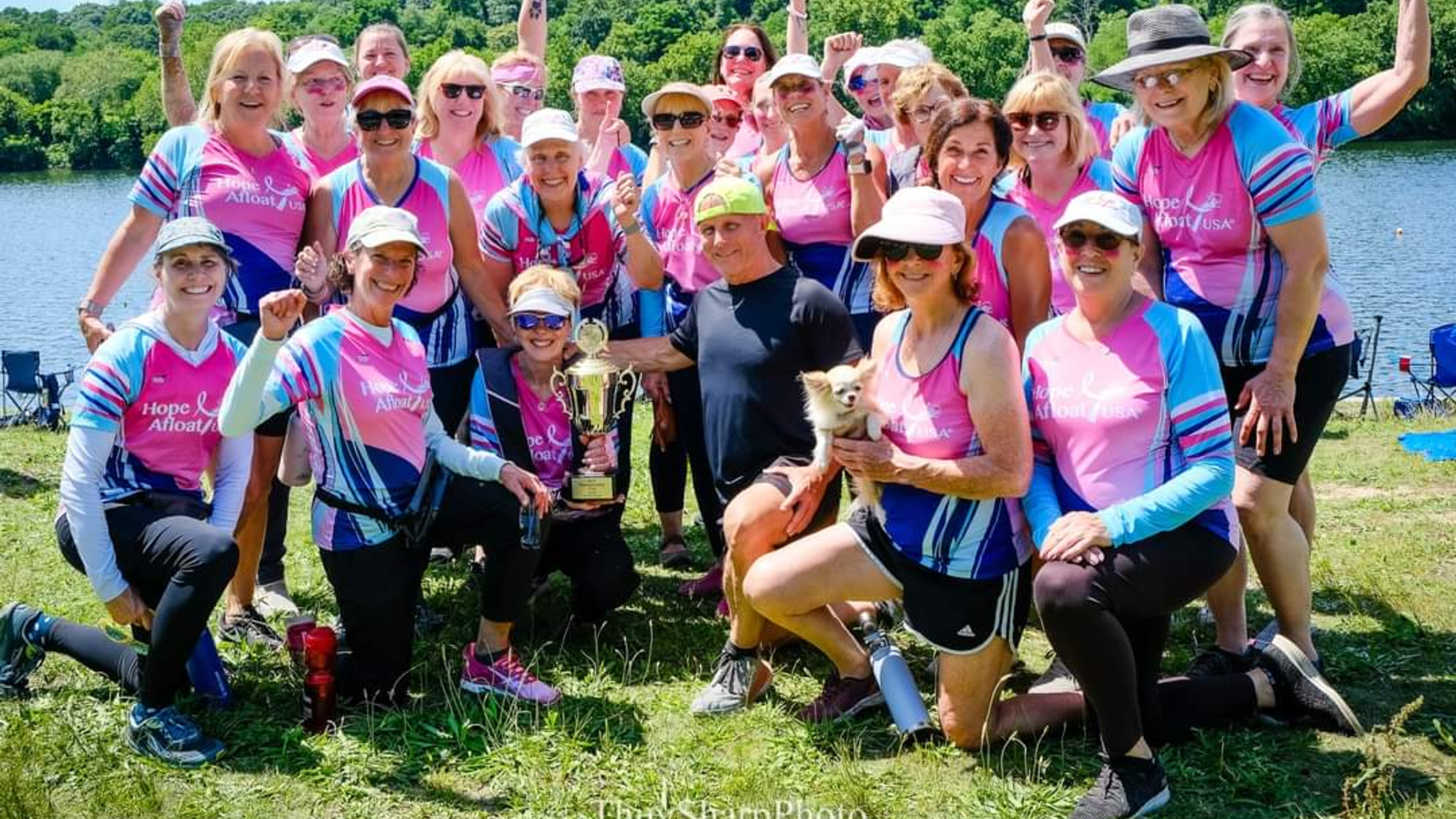 Hope Afloat team members gathering around a trophy outside. 