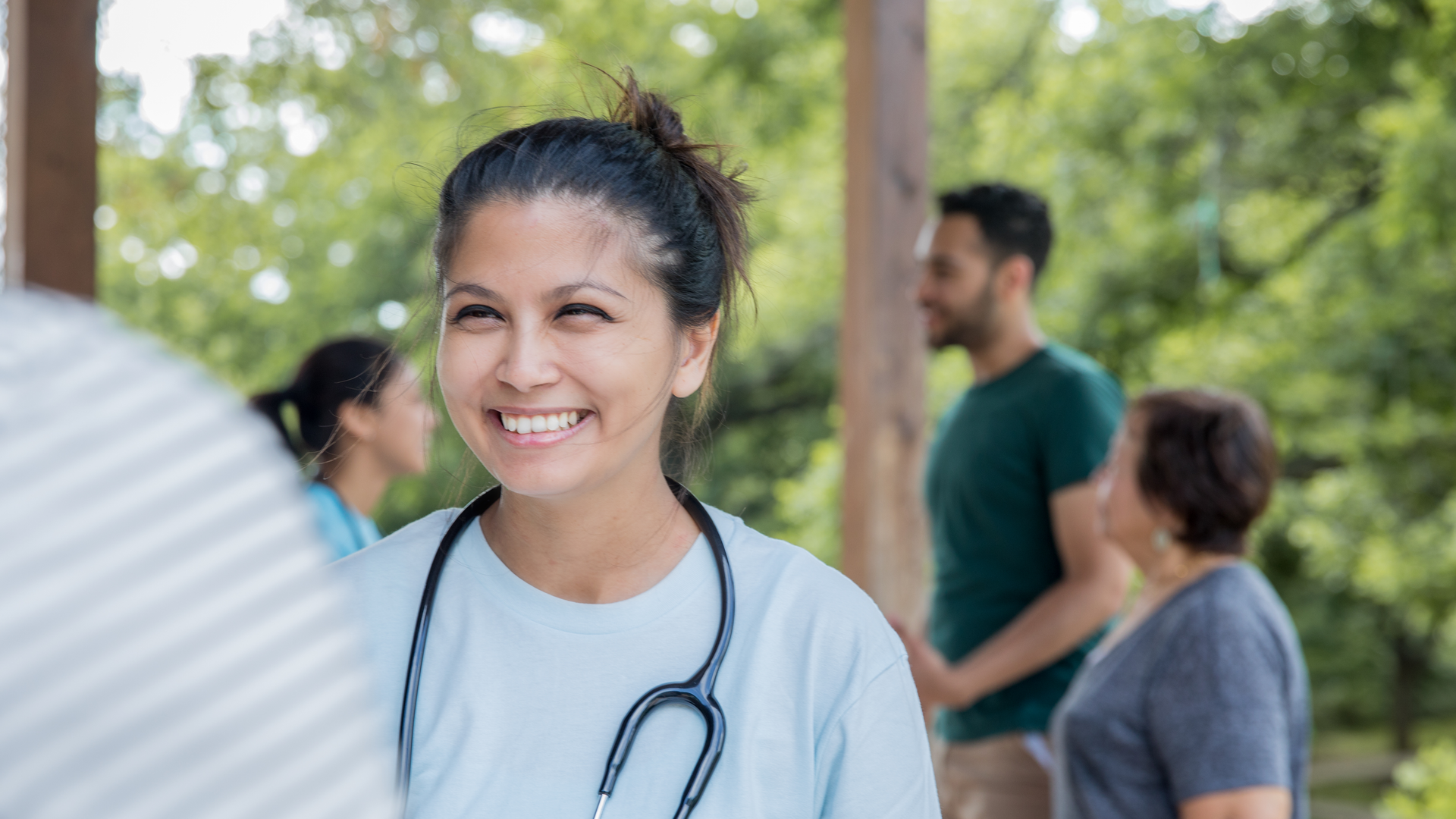 Friendly nurse helps patient during an outdoor health fair or free clinic event