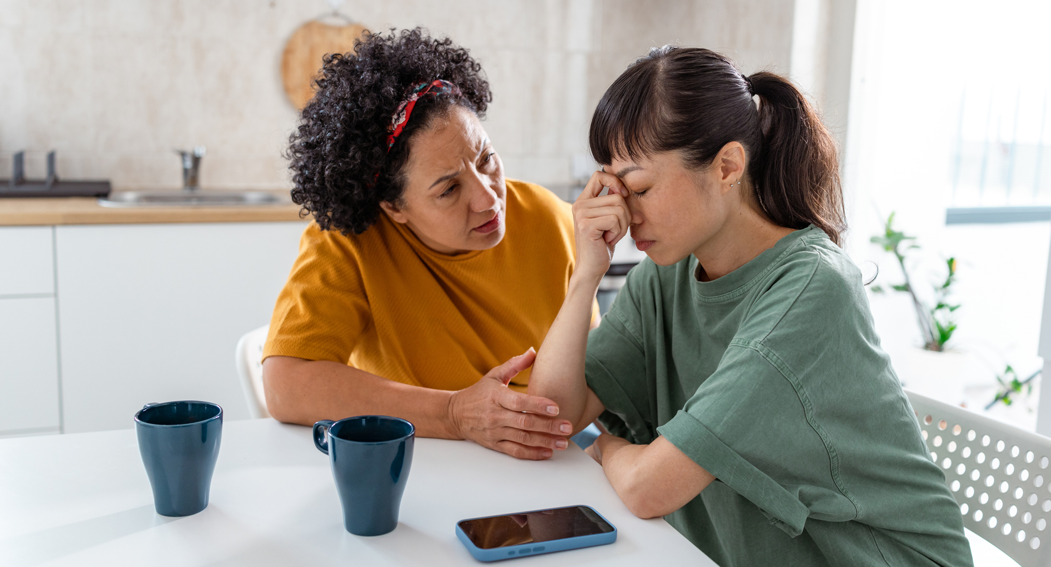 A woman consoling another woman who appears stressed.