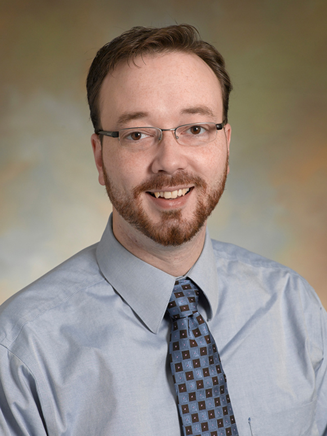 Headshot of John Wood, MD, in a blue shirt and tie