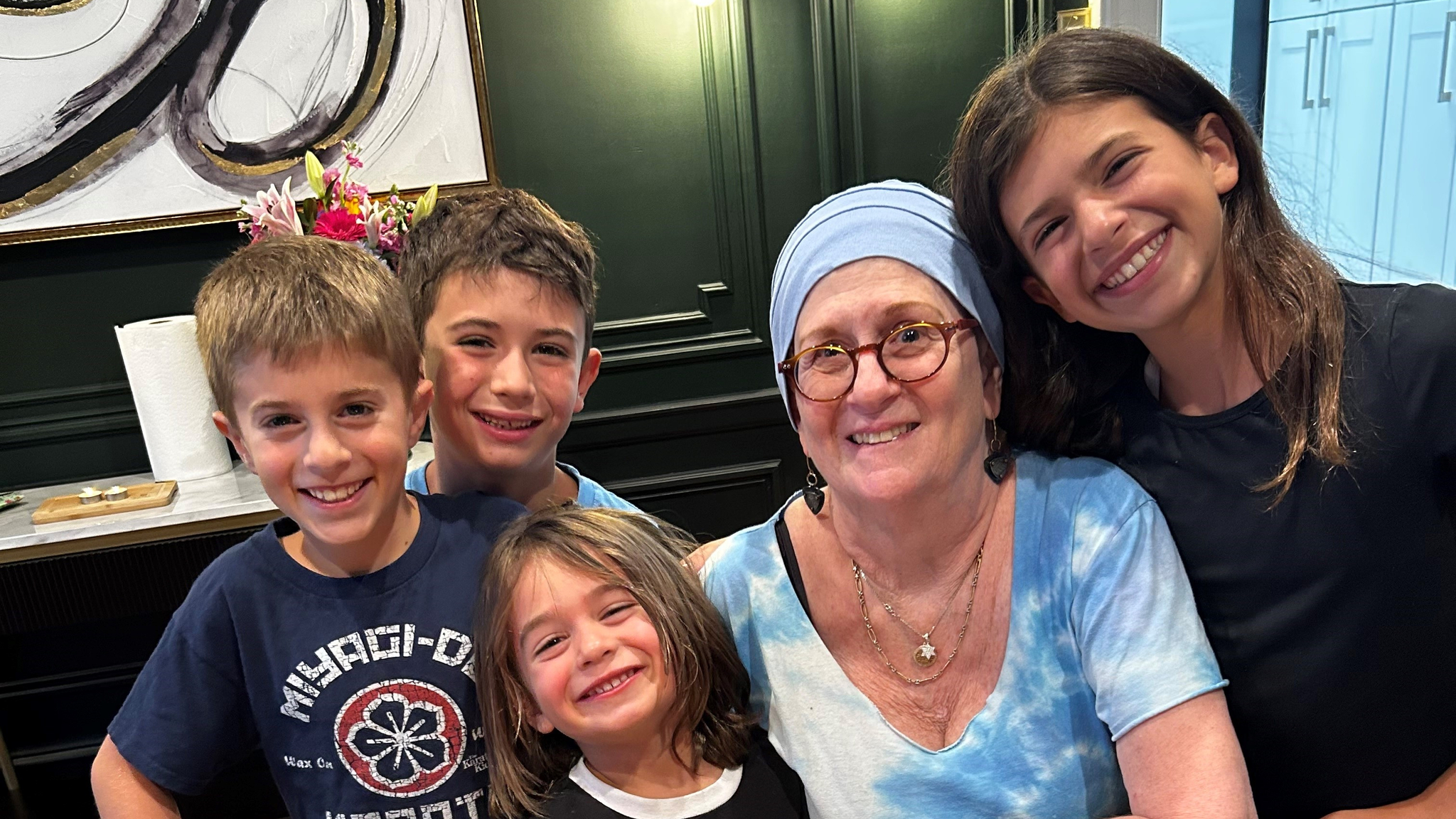 Lynn Oxenberg smiles with her grandchildren and 73rd birthday cake that reads, "Happy Birthday Bubby"