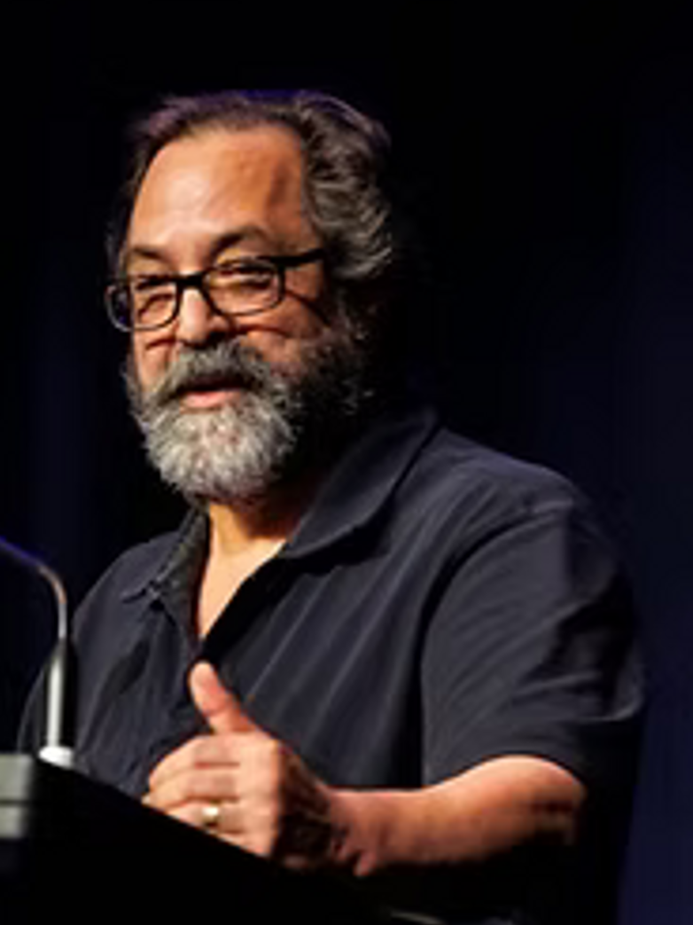 Michael Perlis speaking behind a podium