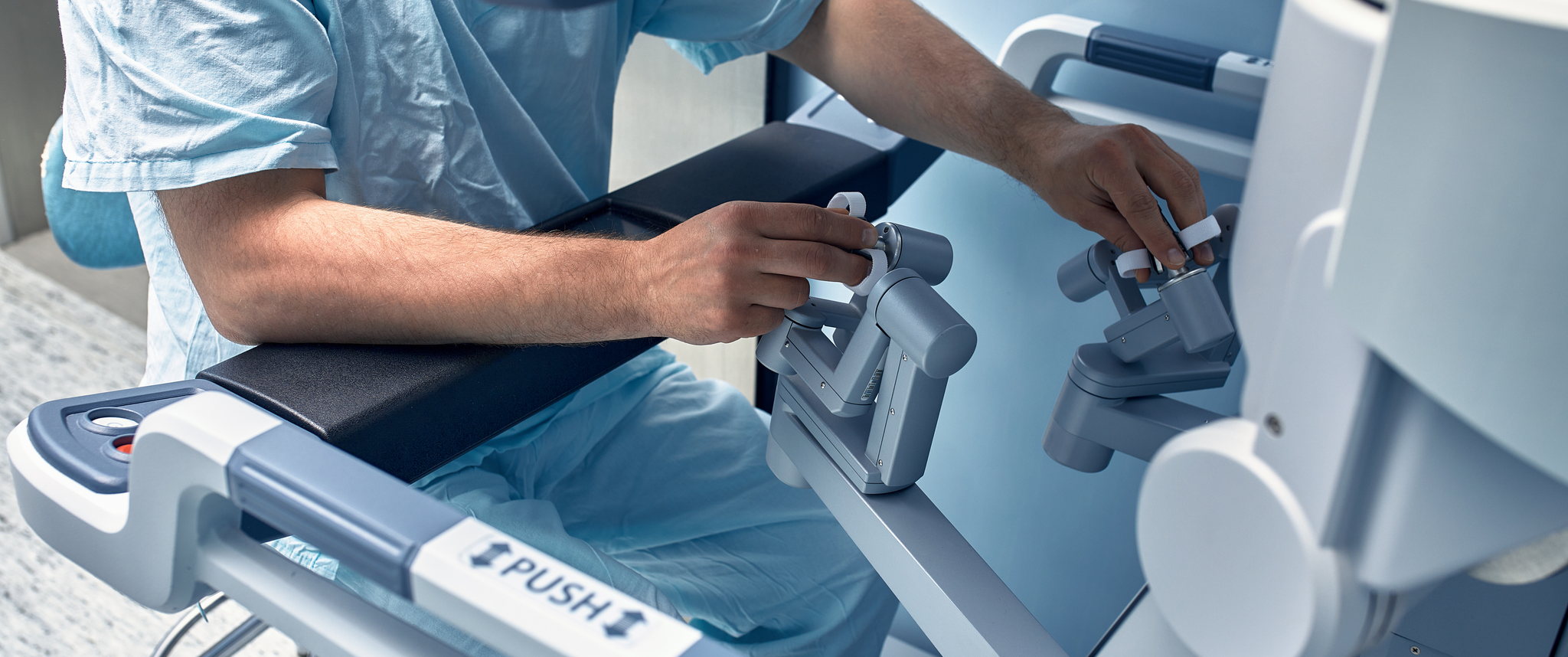 A surgeon controls a robot for surgery
