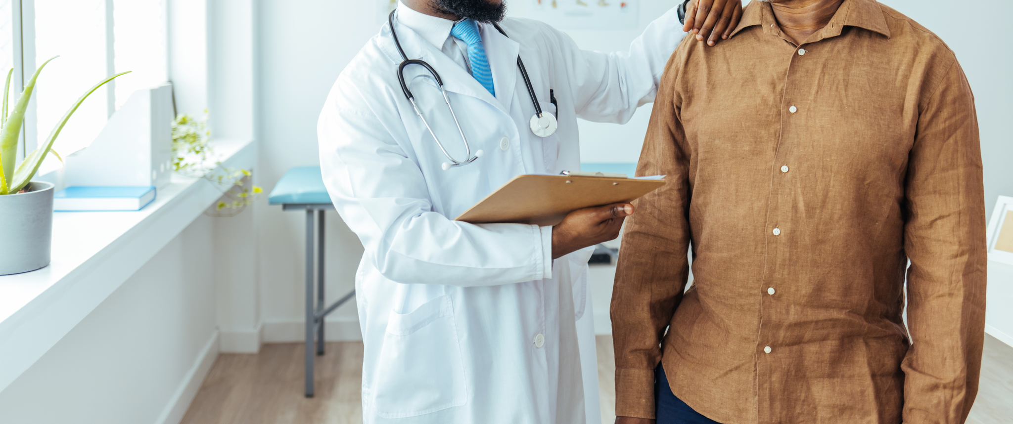 African American patient smiling with doctor in examination room