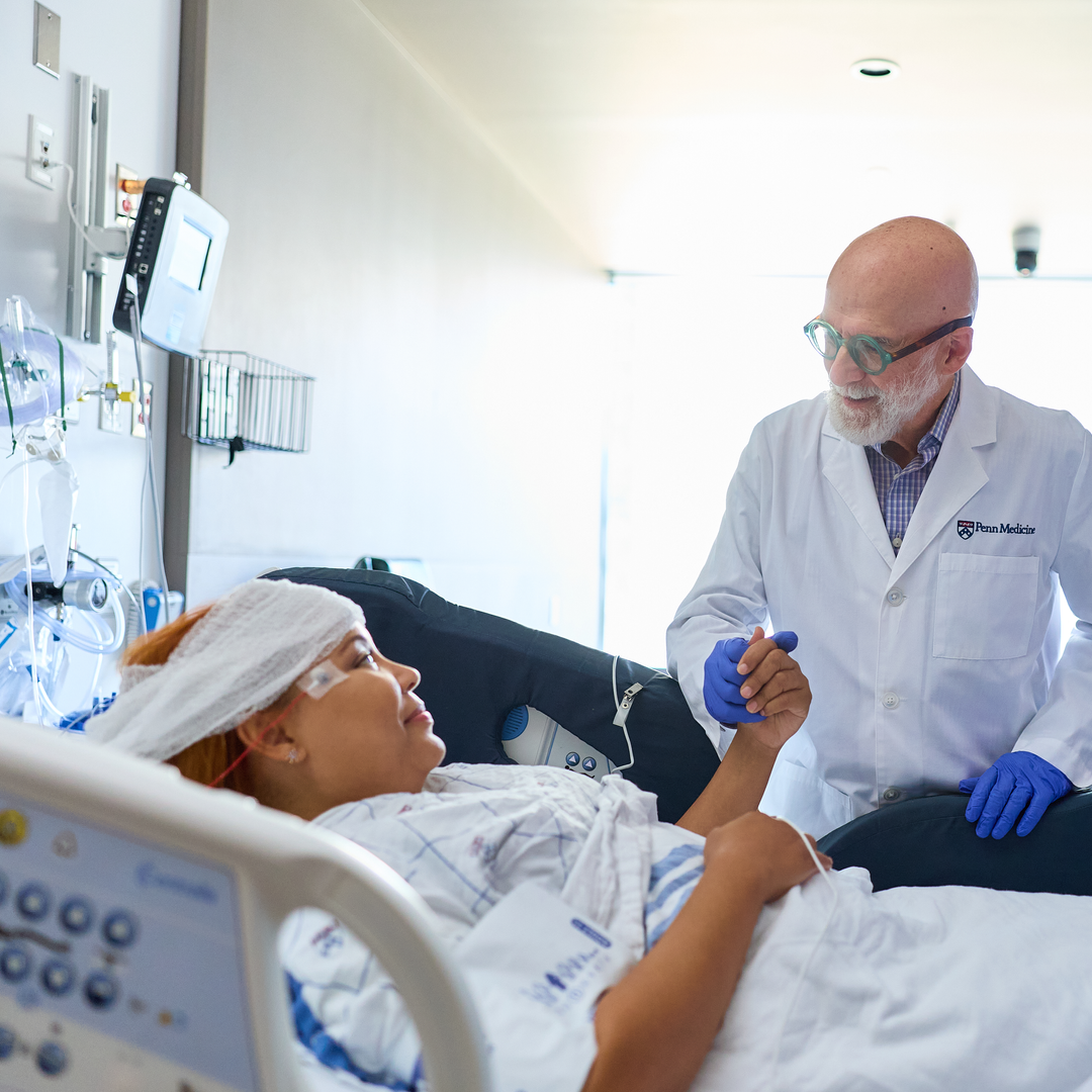A neurologist meets a patient in her hospital room