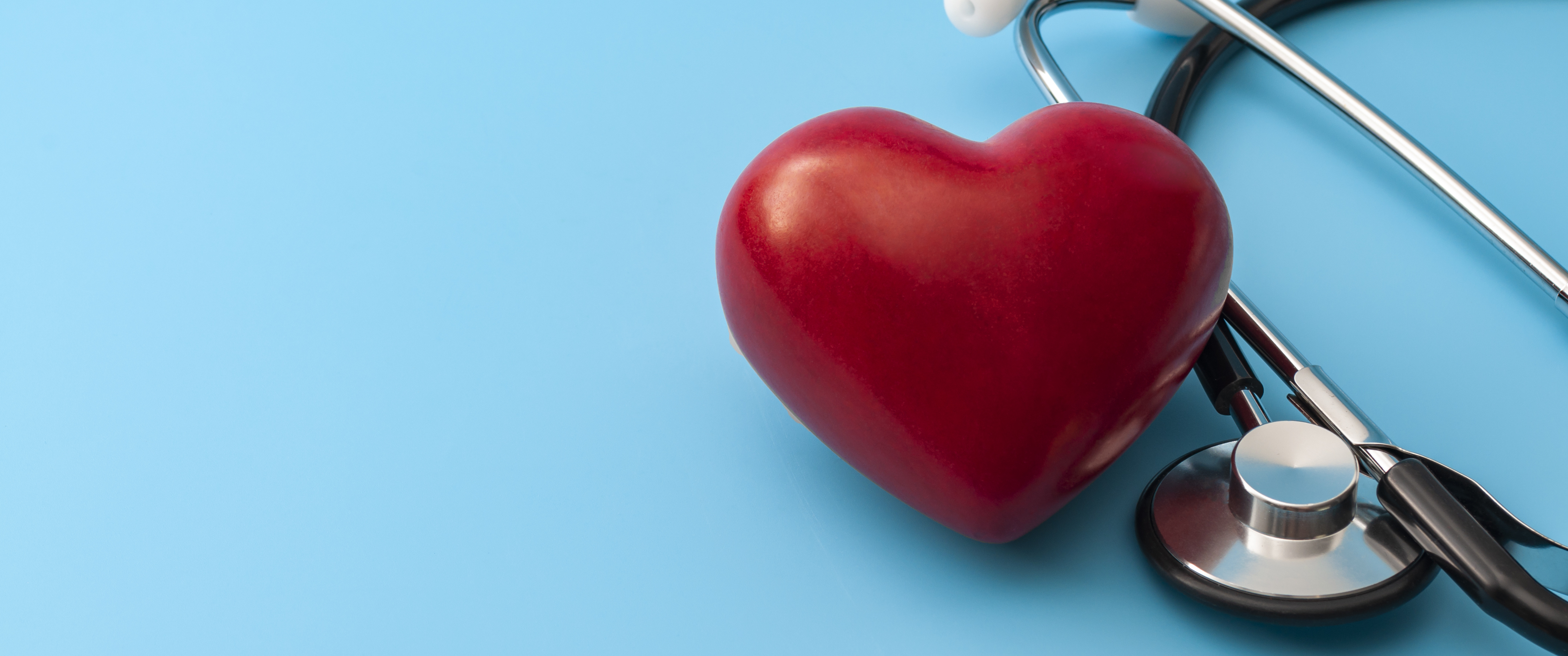Red heart and stethoscope isolated on blue background